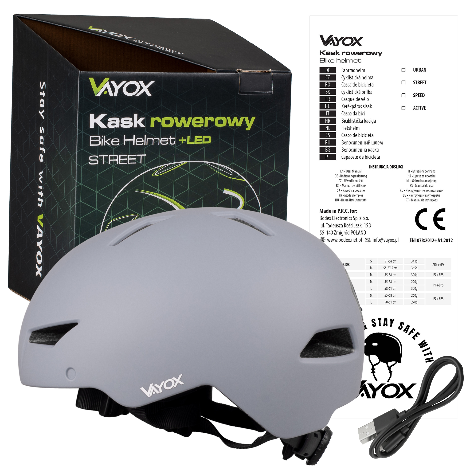 Szary kask rowerowy Vayox z LED na opakowaniu i kablu ładowania.
