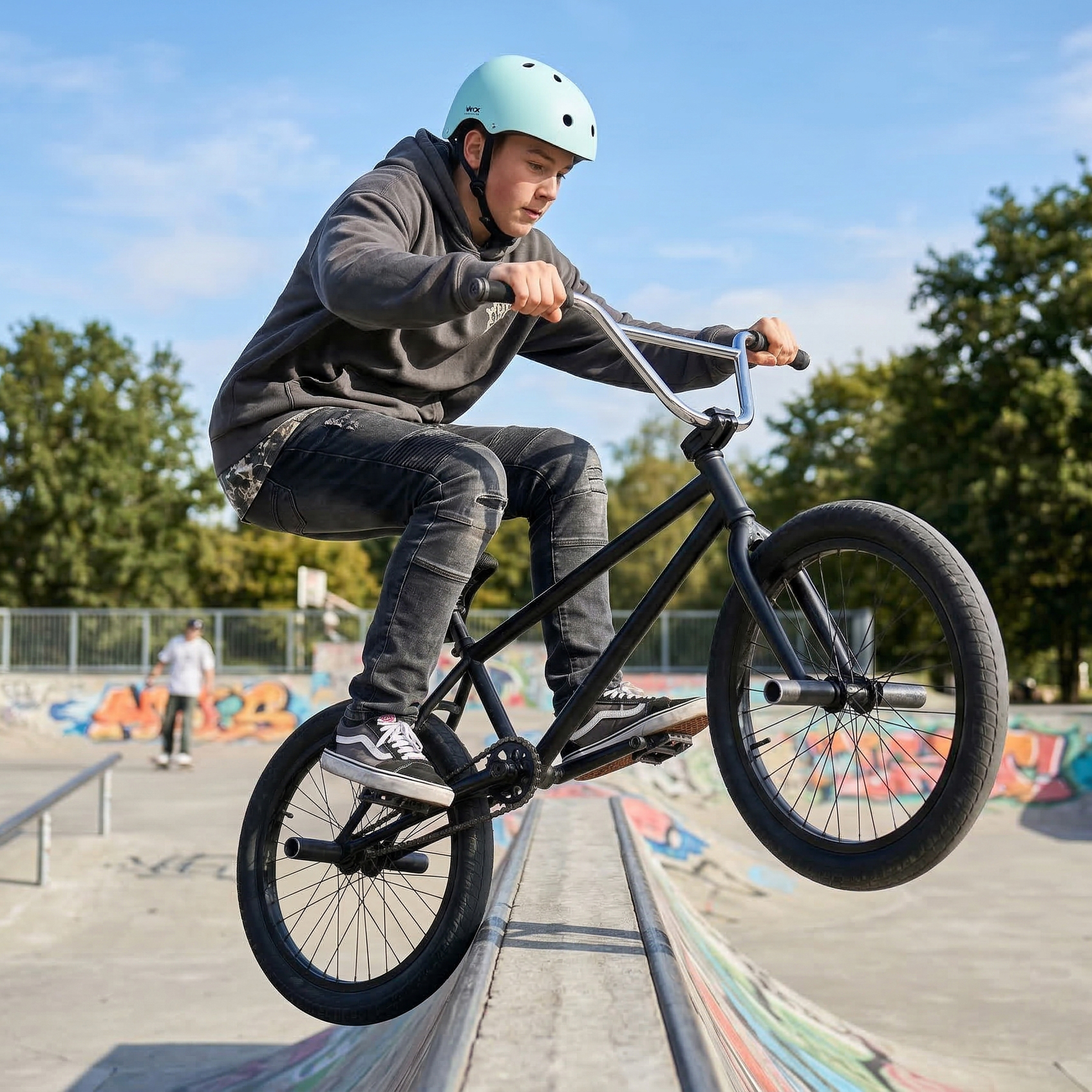 Nastolatek na rowerze BMX przejeżdża przez rampę w skateparku.