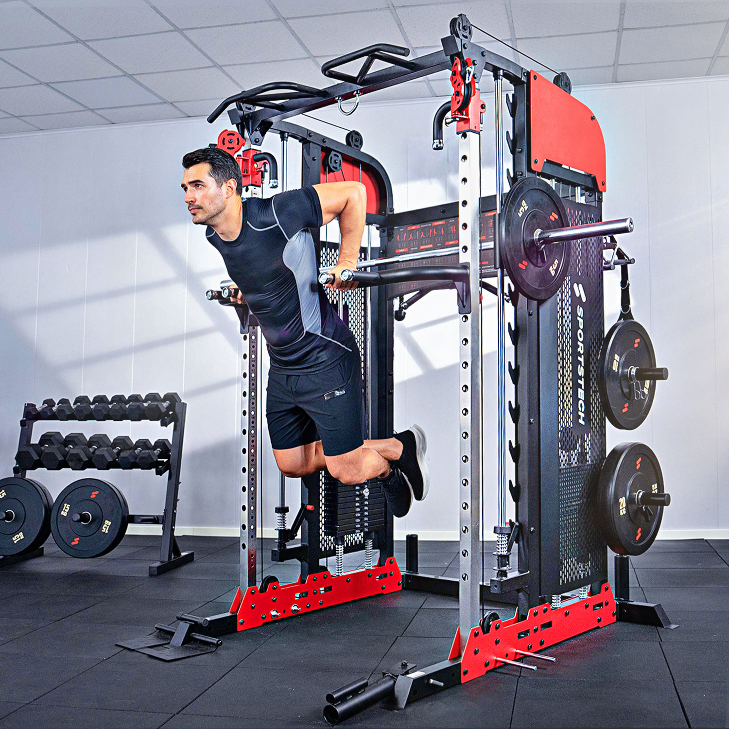 Mann macht Dips an einem Fitnessgerät, Hantelständer im Hintergrund.