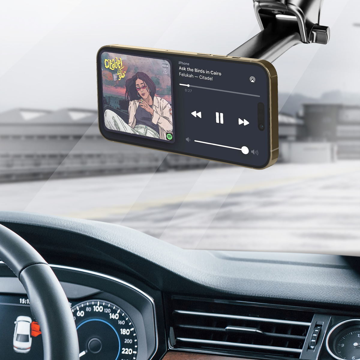 Goldenes iPhone spielt Musik im Auto. Blick auf Armaturenbrett und Straße.