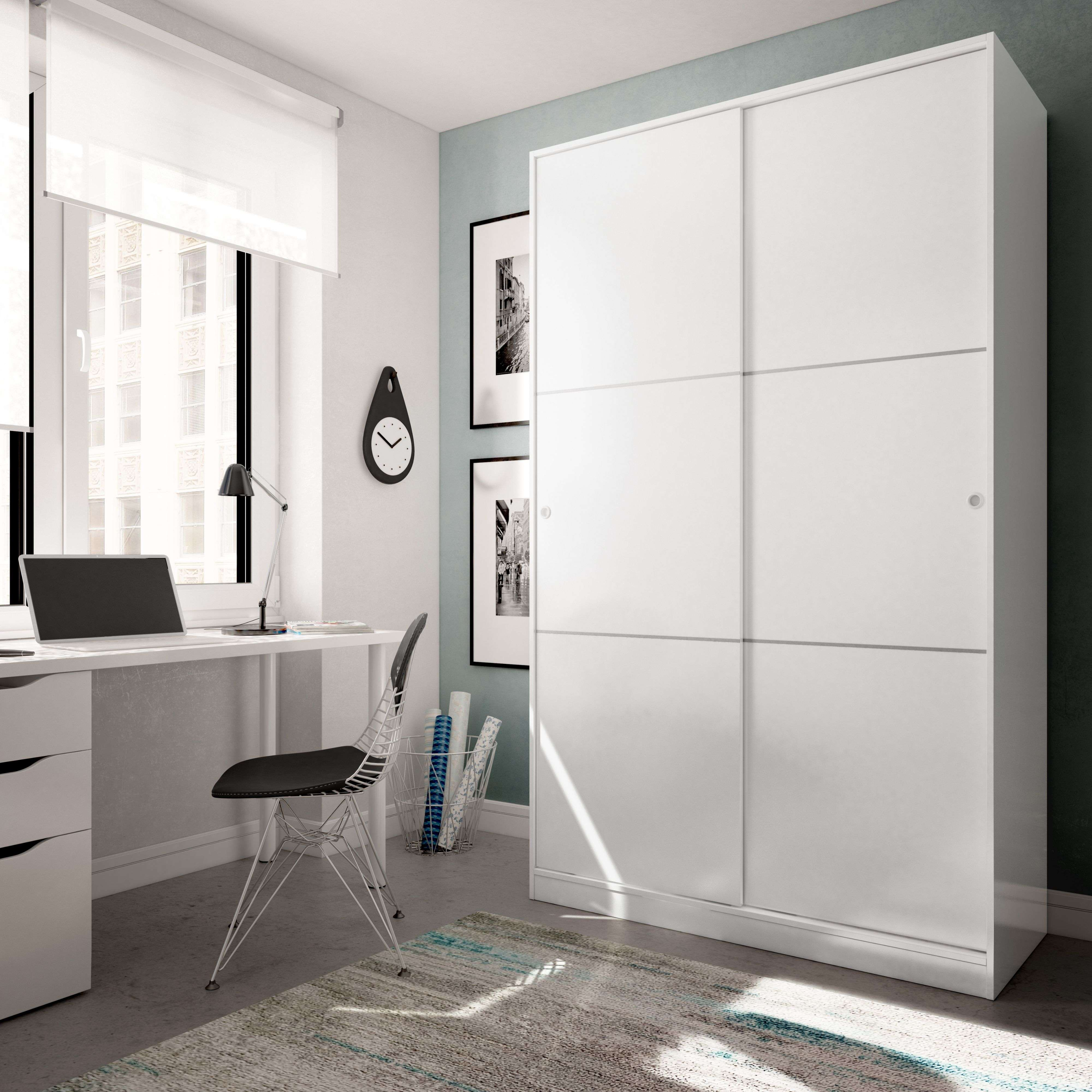 Un dormitorio moderno con armario blanco, escritorio, portátil y silla.