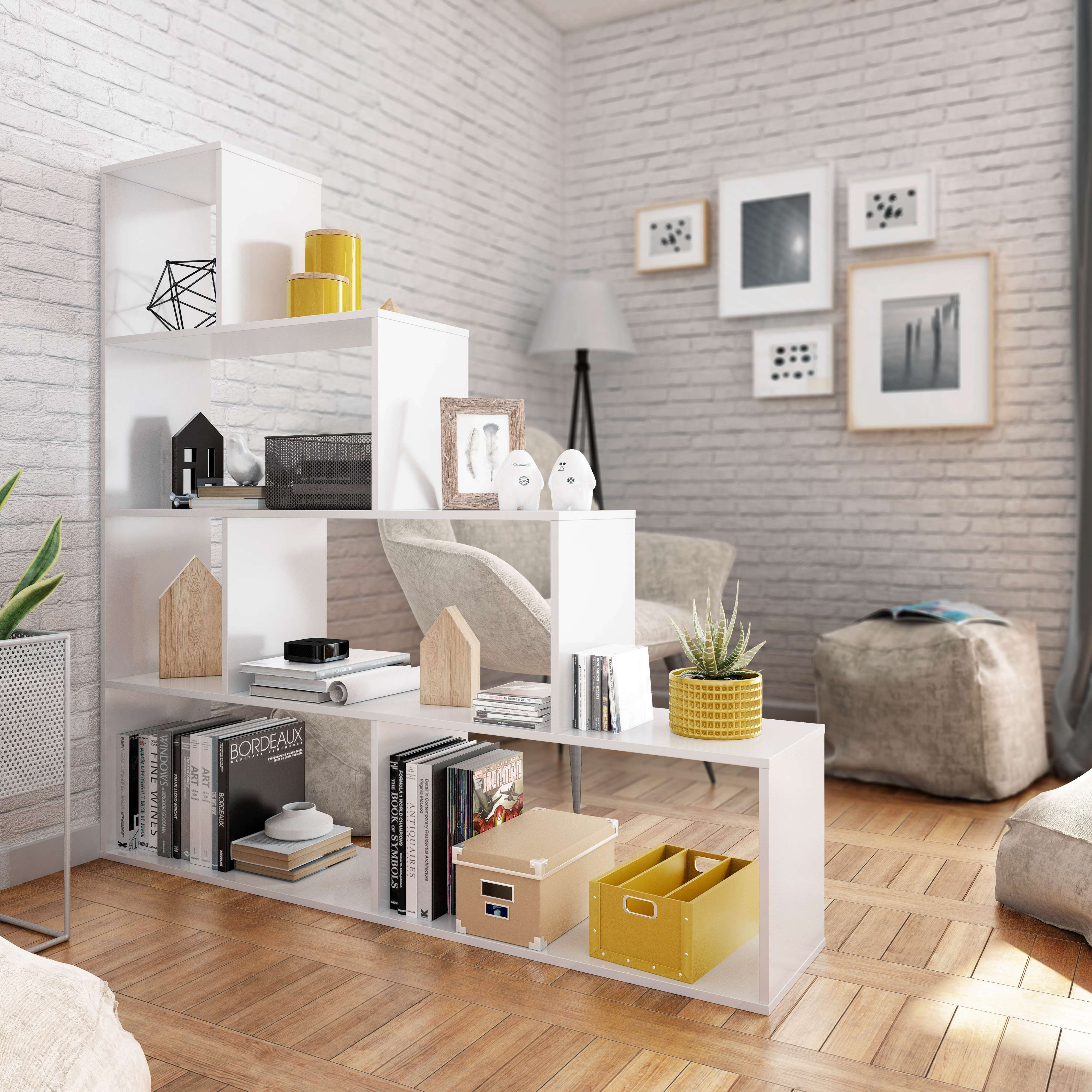 Estantería blanca con libros, decoración y plantas contra pared de ladrillos.