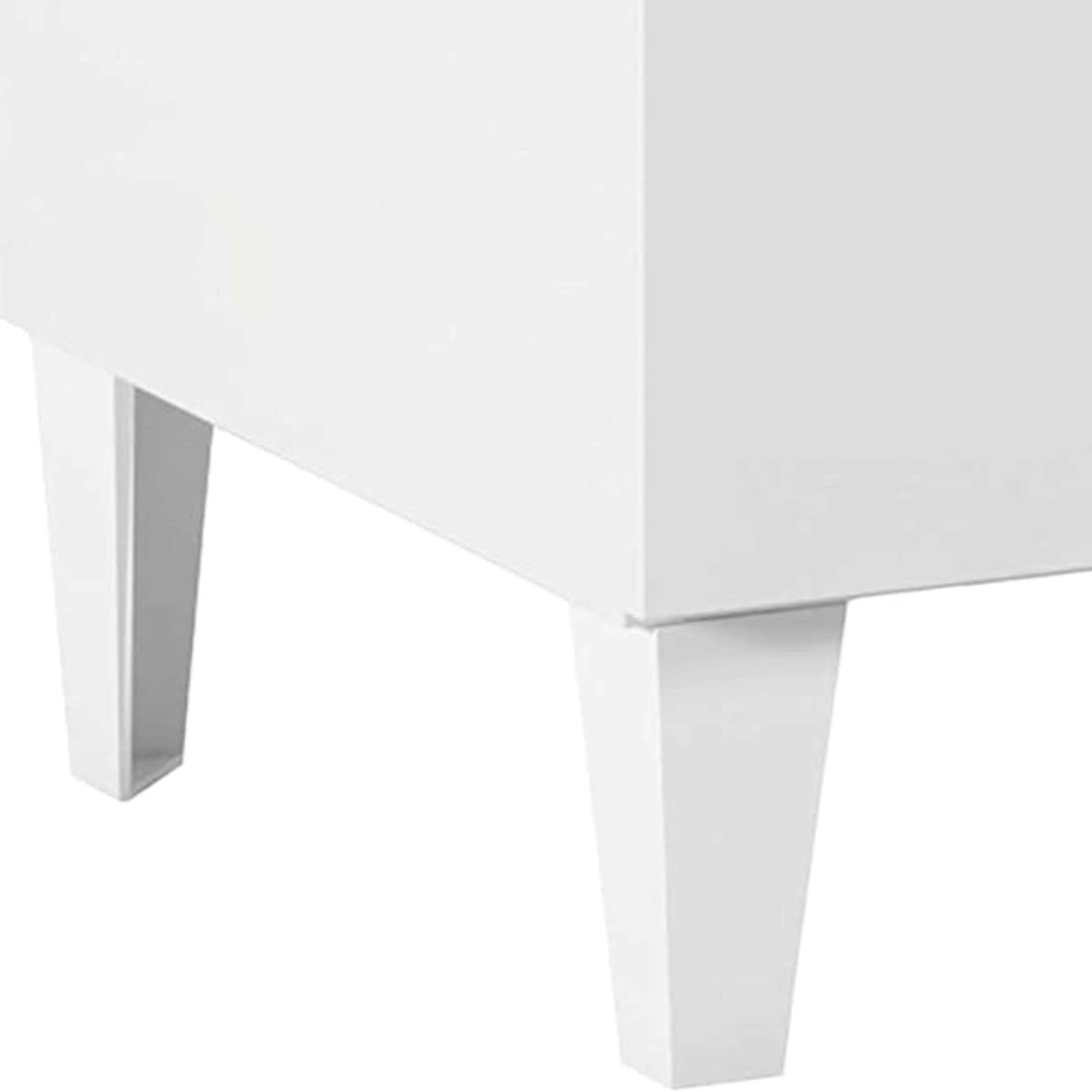 Primer plano de cuatro patas de mueble blancas que sostienen parte de un objeto rectangular blanco.