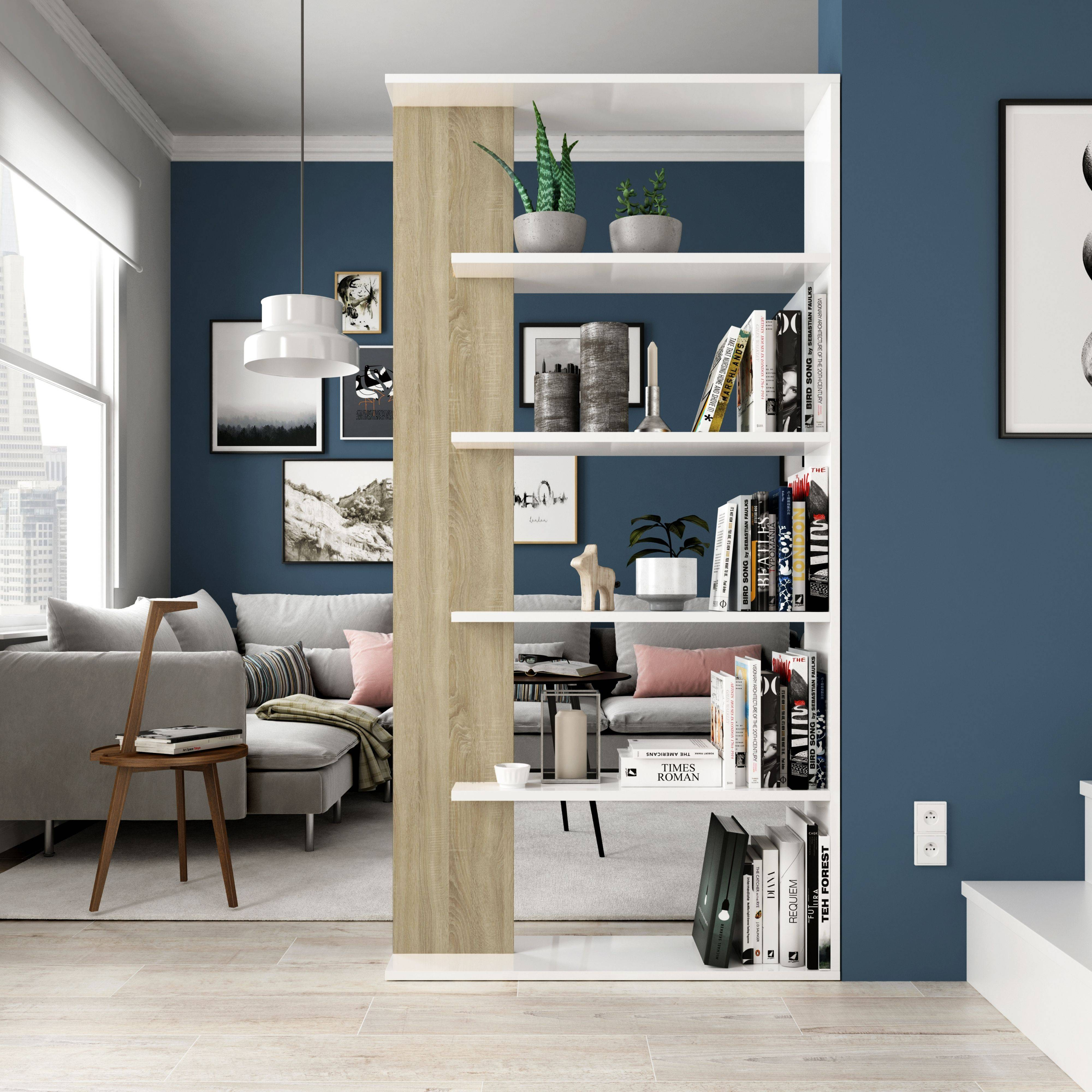 Una estantería con libros, plantas y decoración junto a un sofá.