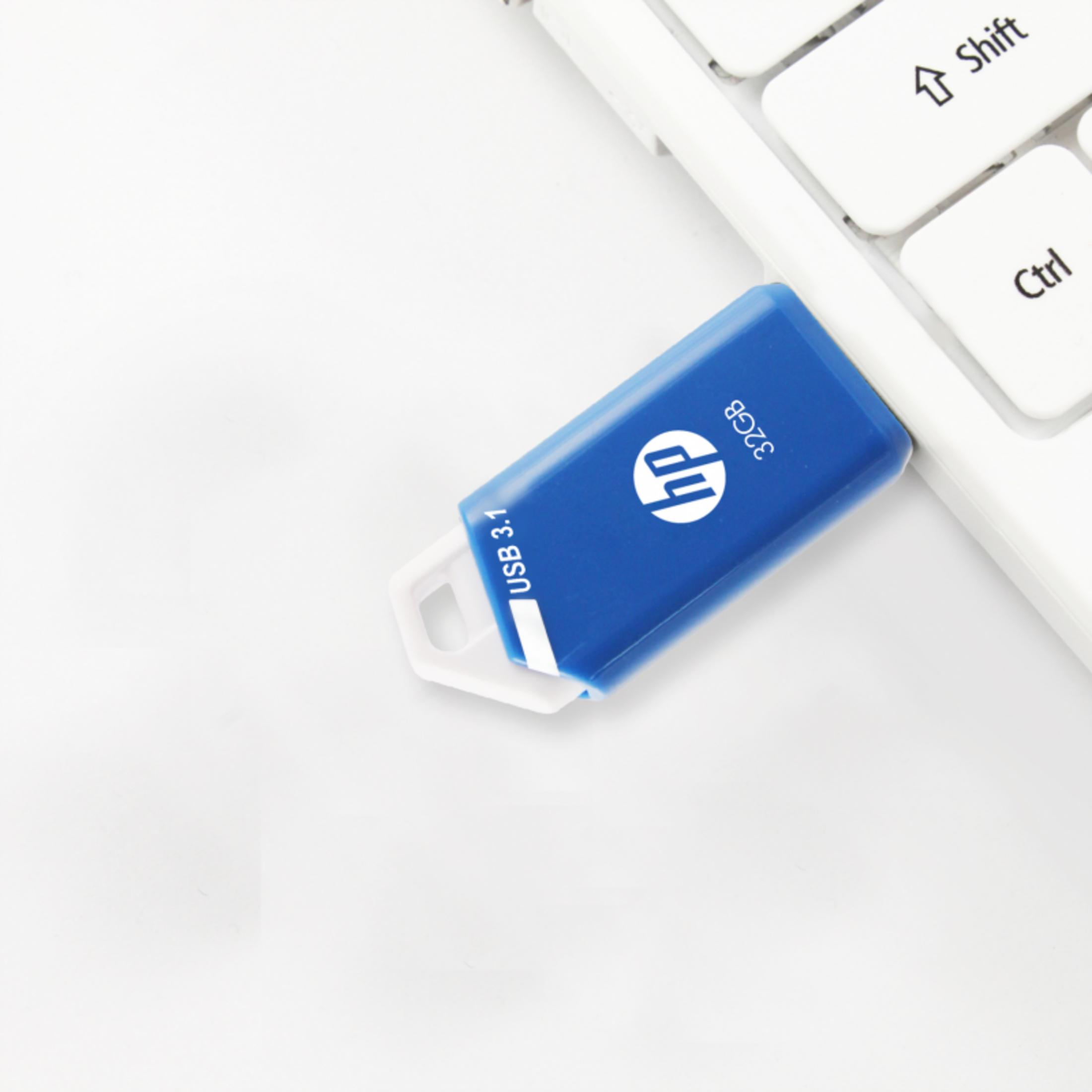 Niebieski pendrive HP 32GB USB 3.1 na białej klawiaturze.