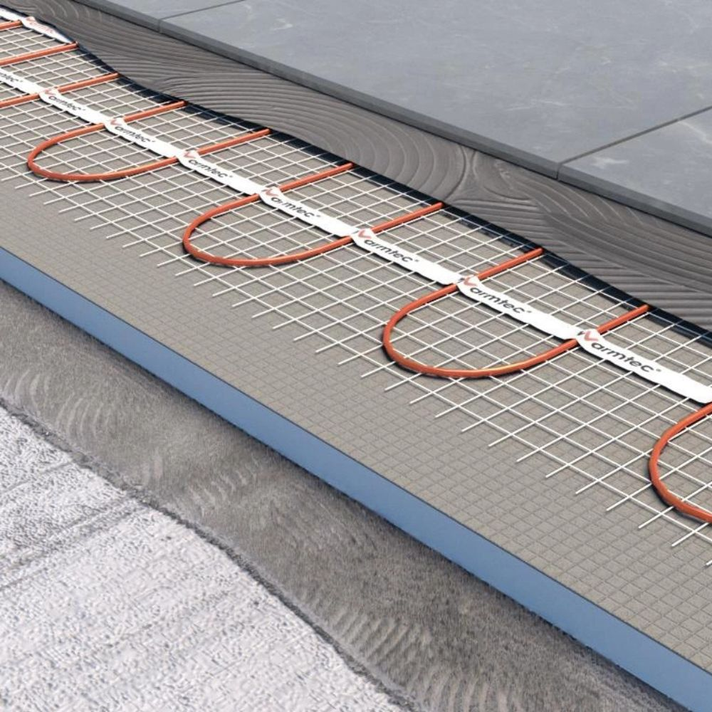 Ogrzewanie podłogowe z pomarańczowymi rurkami na siatce.