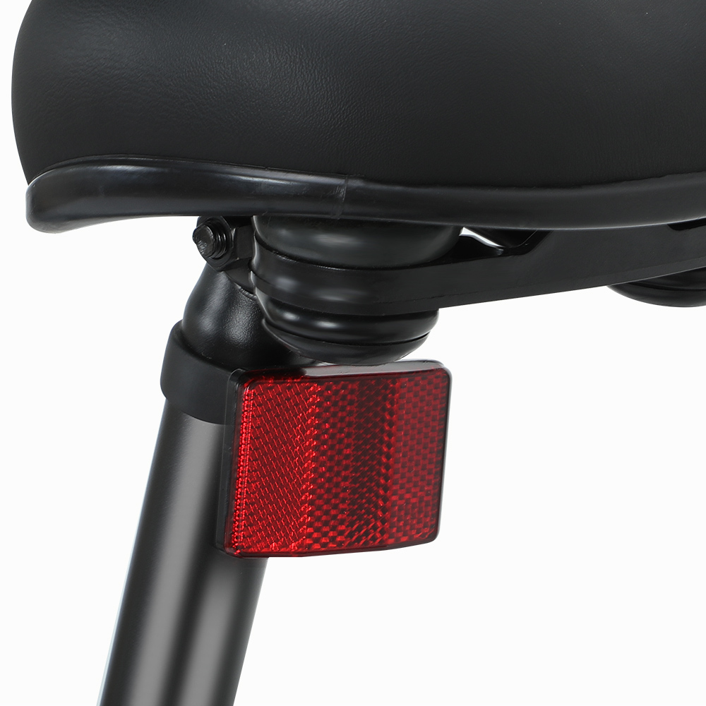 Zbliżenie czerwonego odblasku rowerowego pod czarnym siodełkiem z amortyzacją.