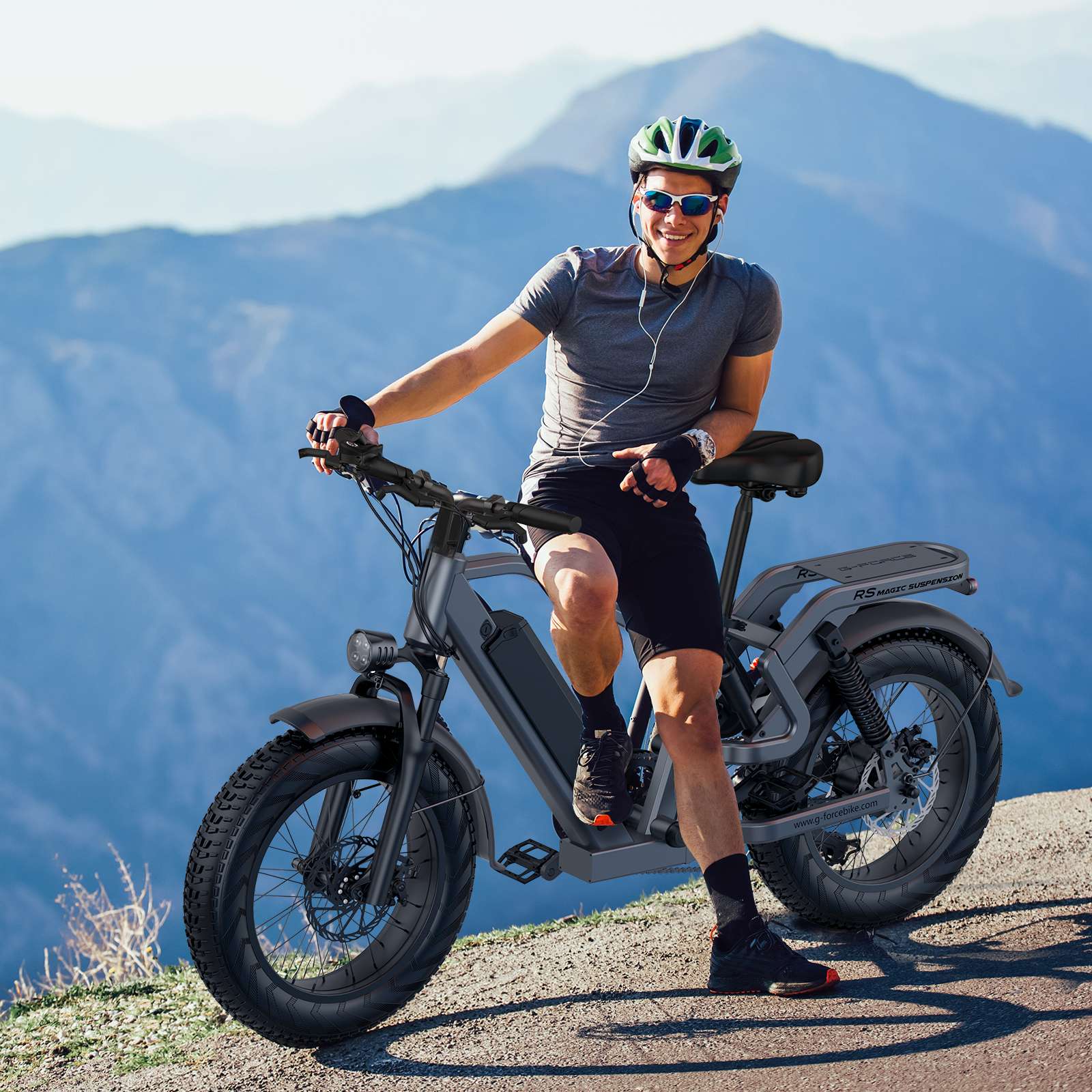 Mężczyzna w kasku i okularach przeciwsłonecznych siedzi na rowerze elektrycznym w górach.