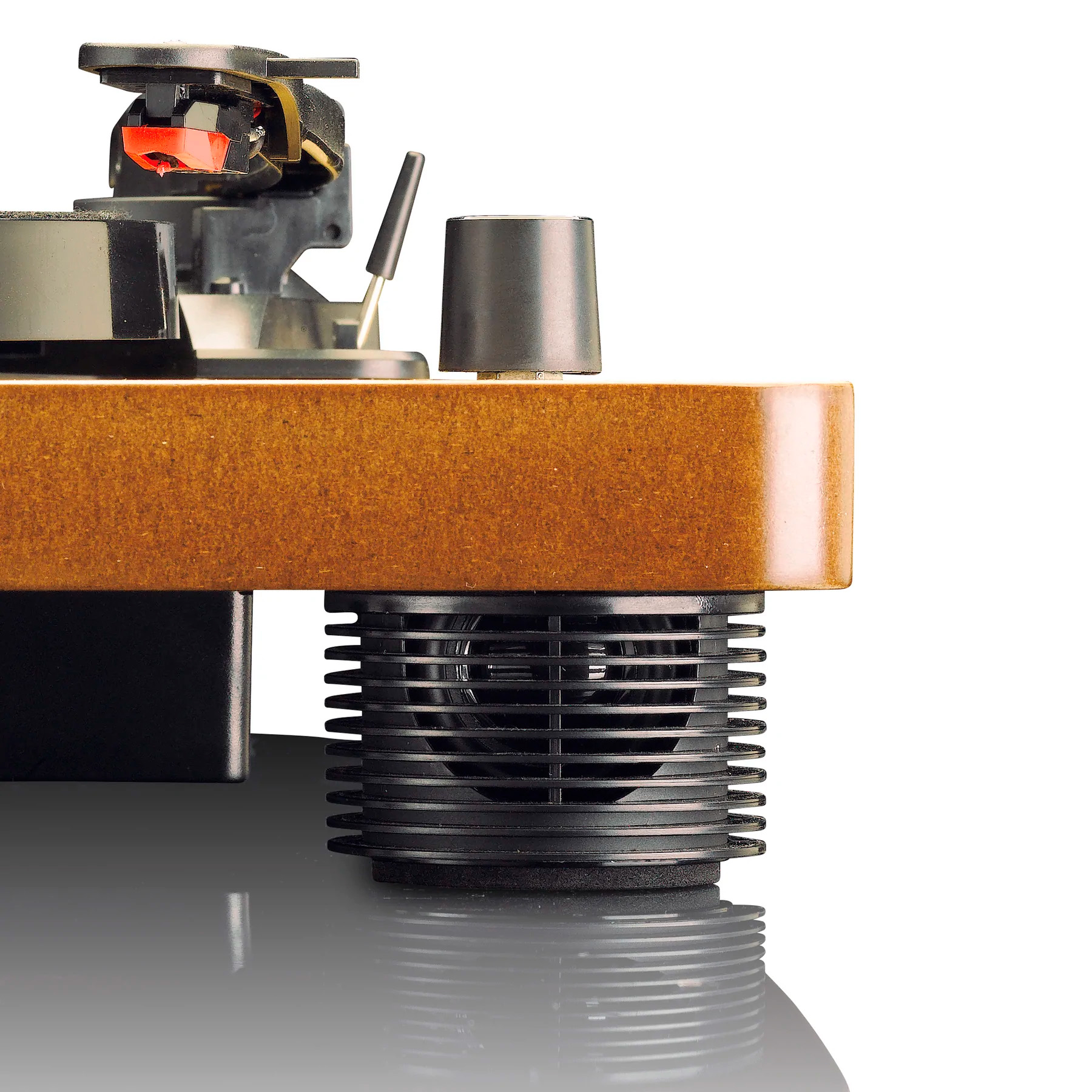 Zbliżenie gramofonu: czerwona igła, czarne ramię, drewniana podstawa i prążkowana czarna podstawa.