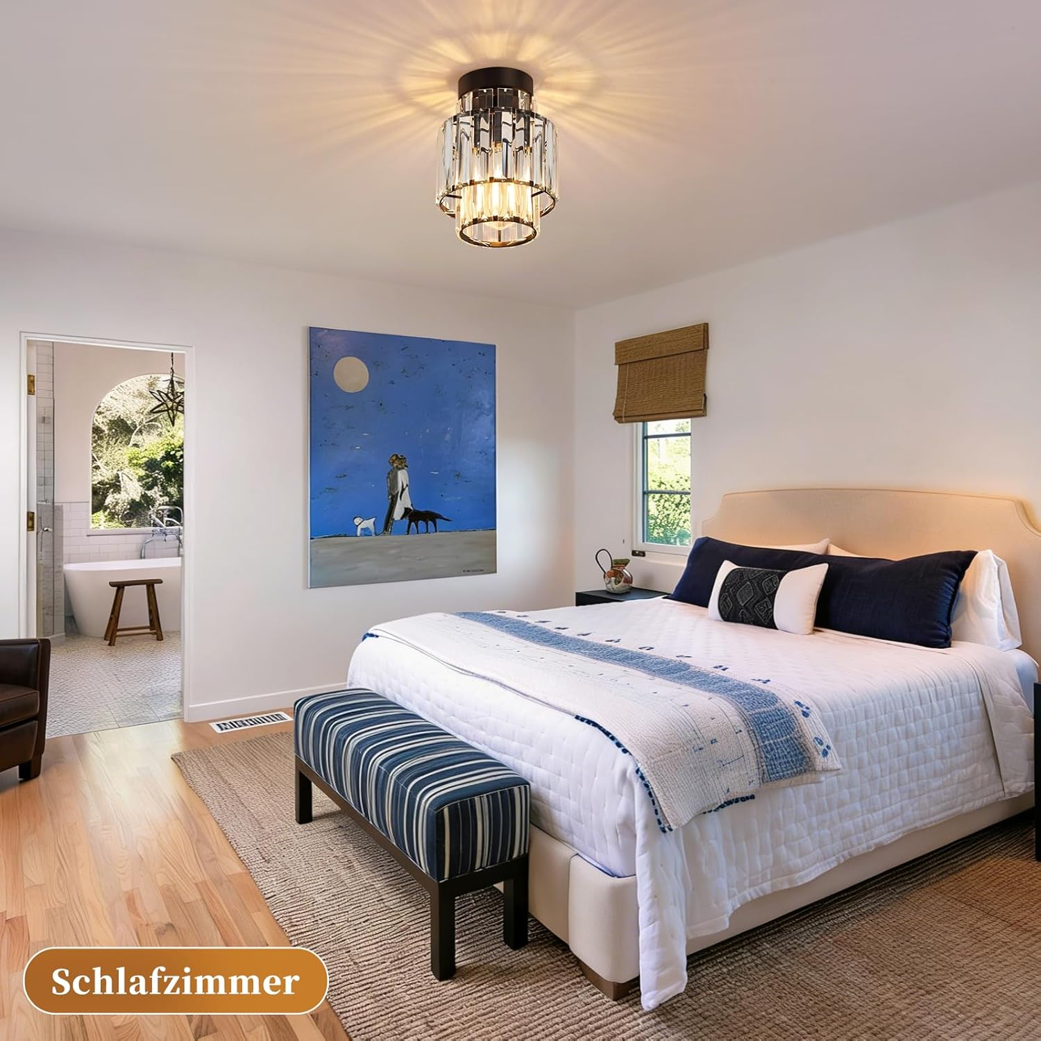 Ein Schlafzimmer mit einem Bett, einer Bank, einem Gemälde und einem Badezimmer im Hintergrund.