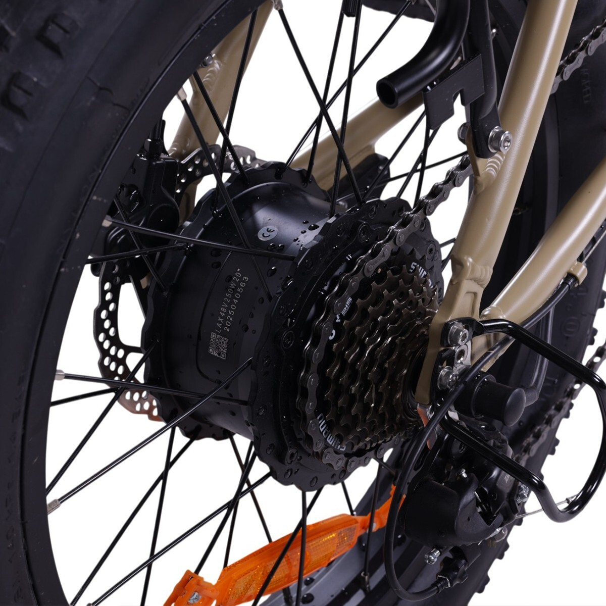 Zbliżenie tylnego koła roweru elektrycznego z widocznym silnikiem, kasetą i łańcuchem.