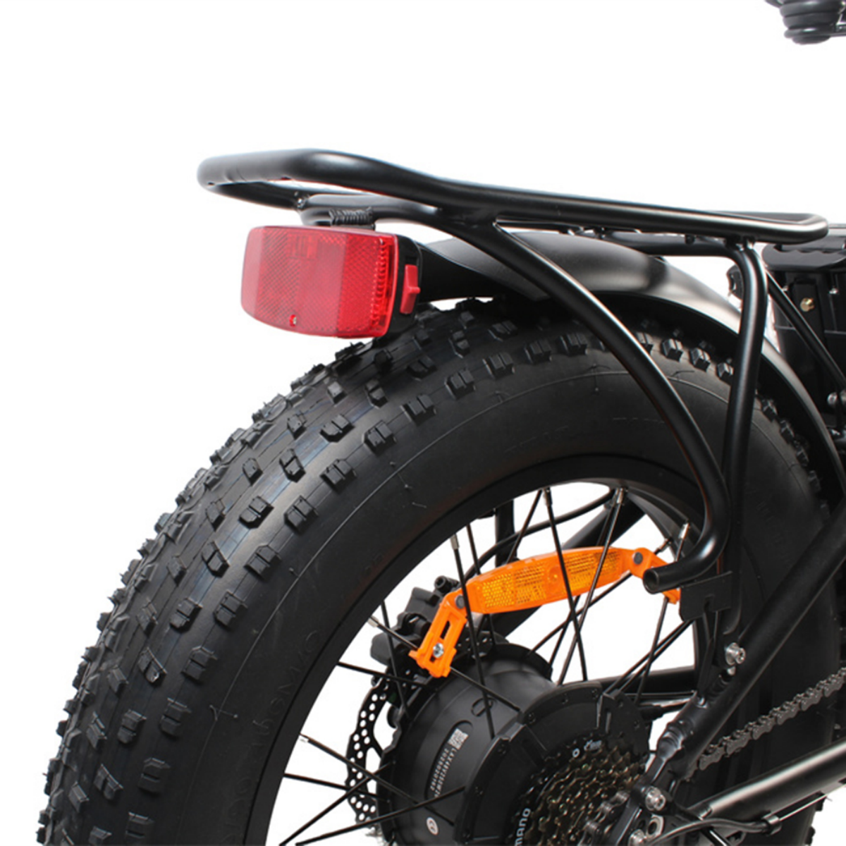 Tylne koło czarnego roweru elektrycznego z grubą oponą, czerwonym odblaskiem i bagażnikiem.