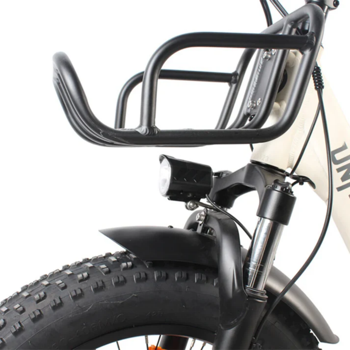 Czarny bagażnik nad przednim kołem i światłem białego roweru.
