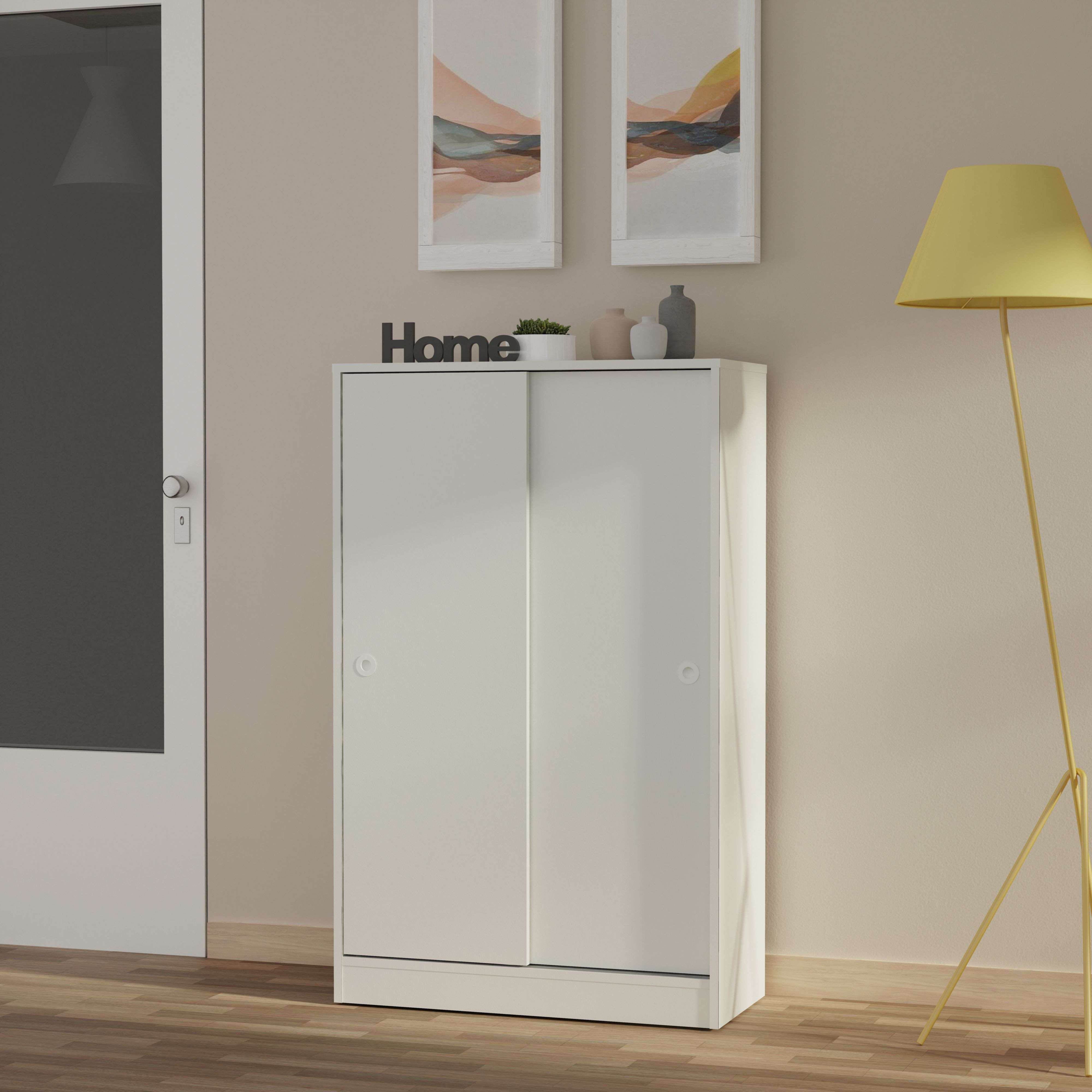 Un armario blanco con puertas correderas sobre suelo de madera.