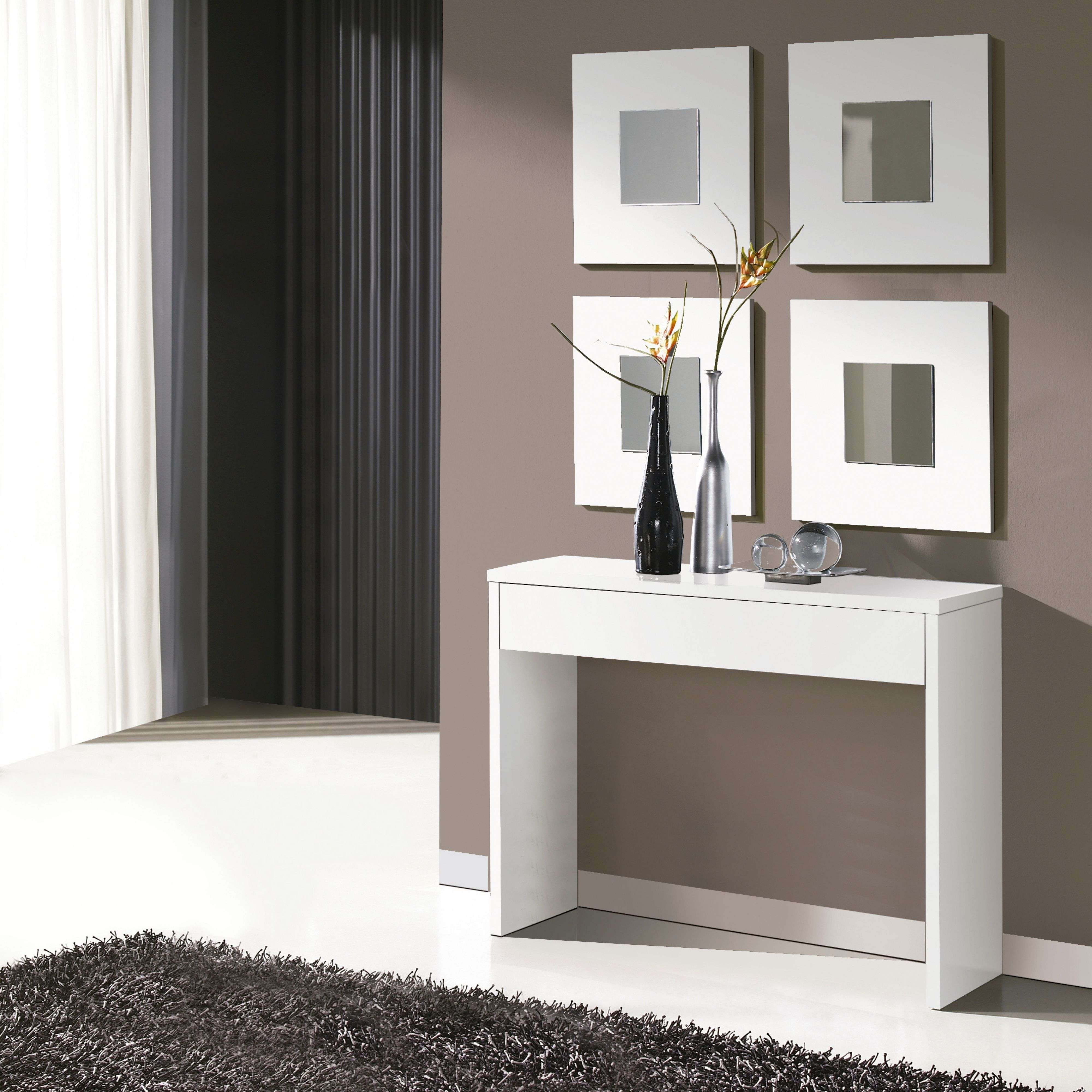 Una mesa consola blanca estrecha con decoración sobre pared marrón.