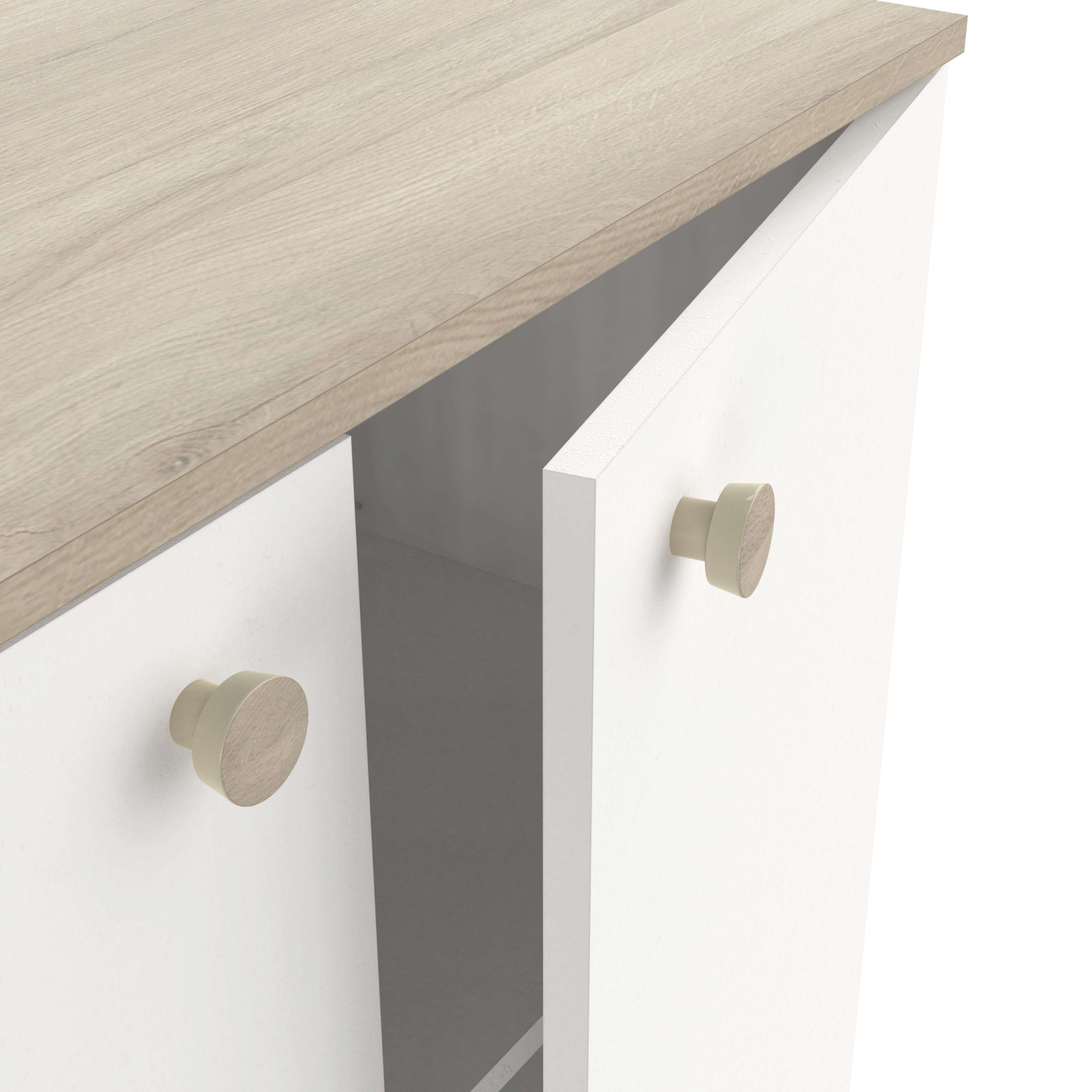Un armario blanco con tiradores de madera y superficie superior de madera.