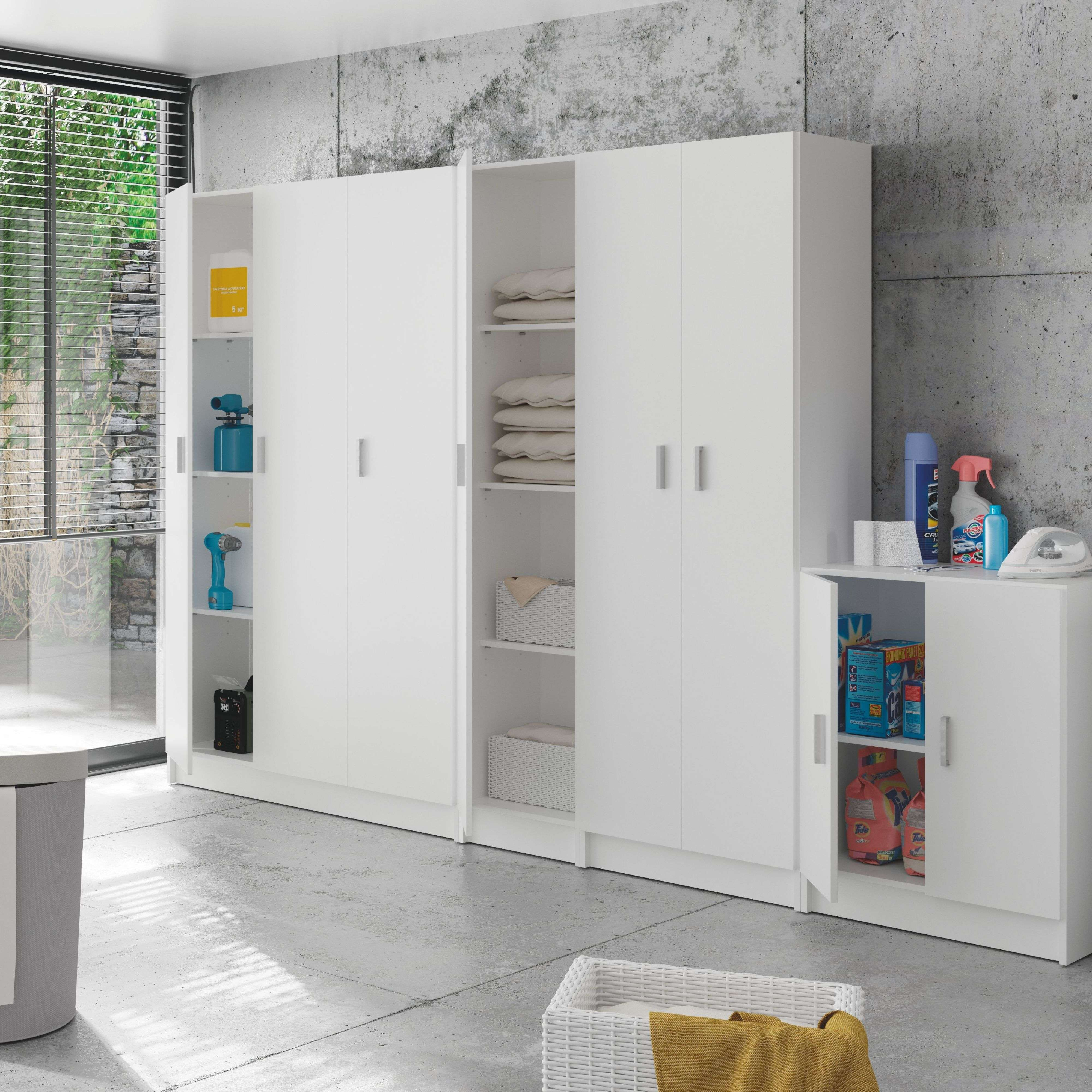 Un lavadero moderno con armarios blancos llenos de artículos de limpieza, ropa y herramientas.