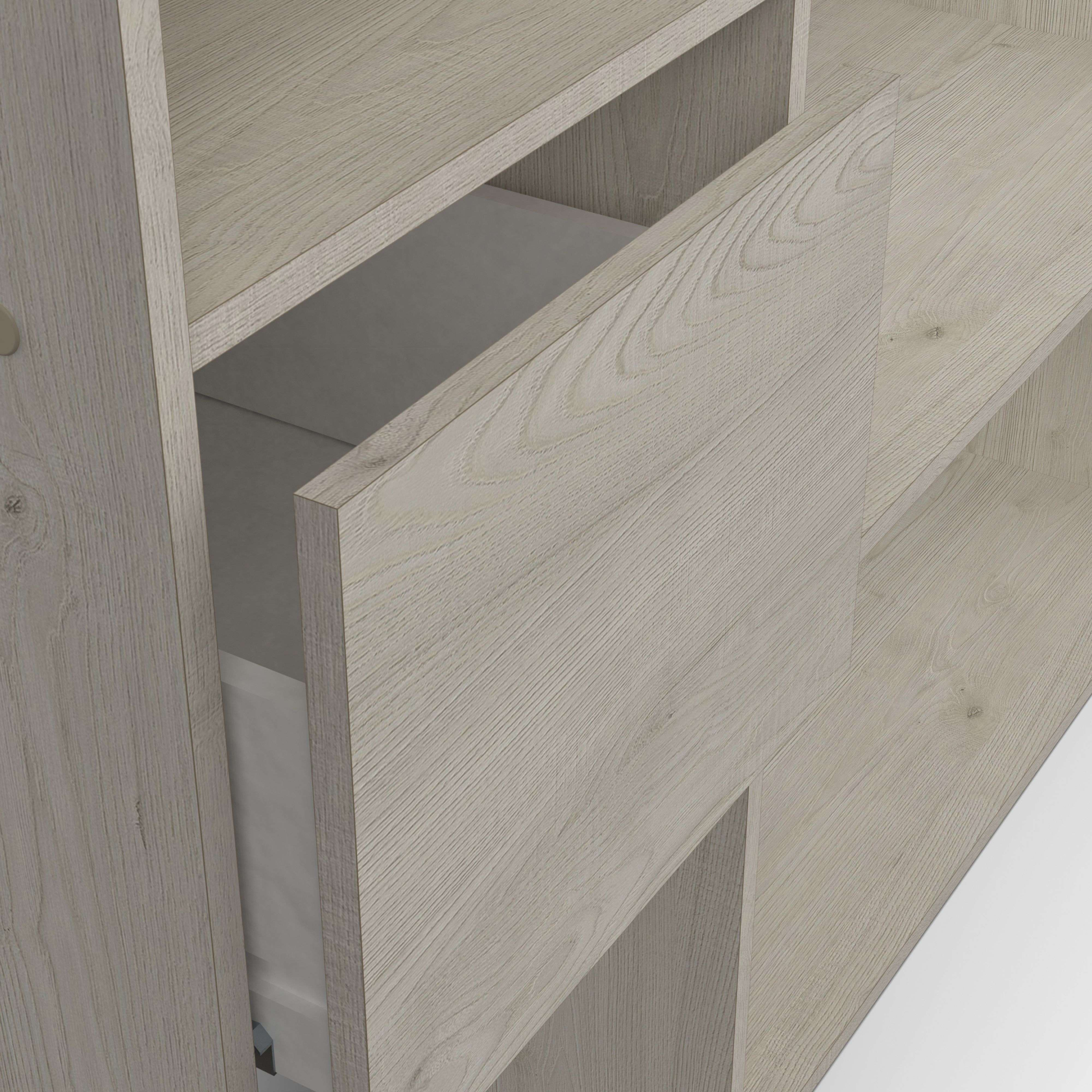 Un armario de madera clara con un cajón abierto. Veta de madera clara.