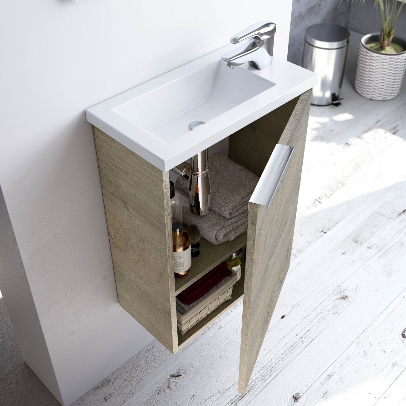 Un mueble de lavabo de madera con puerta abierta, con toallas y artículos de aseo.