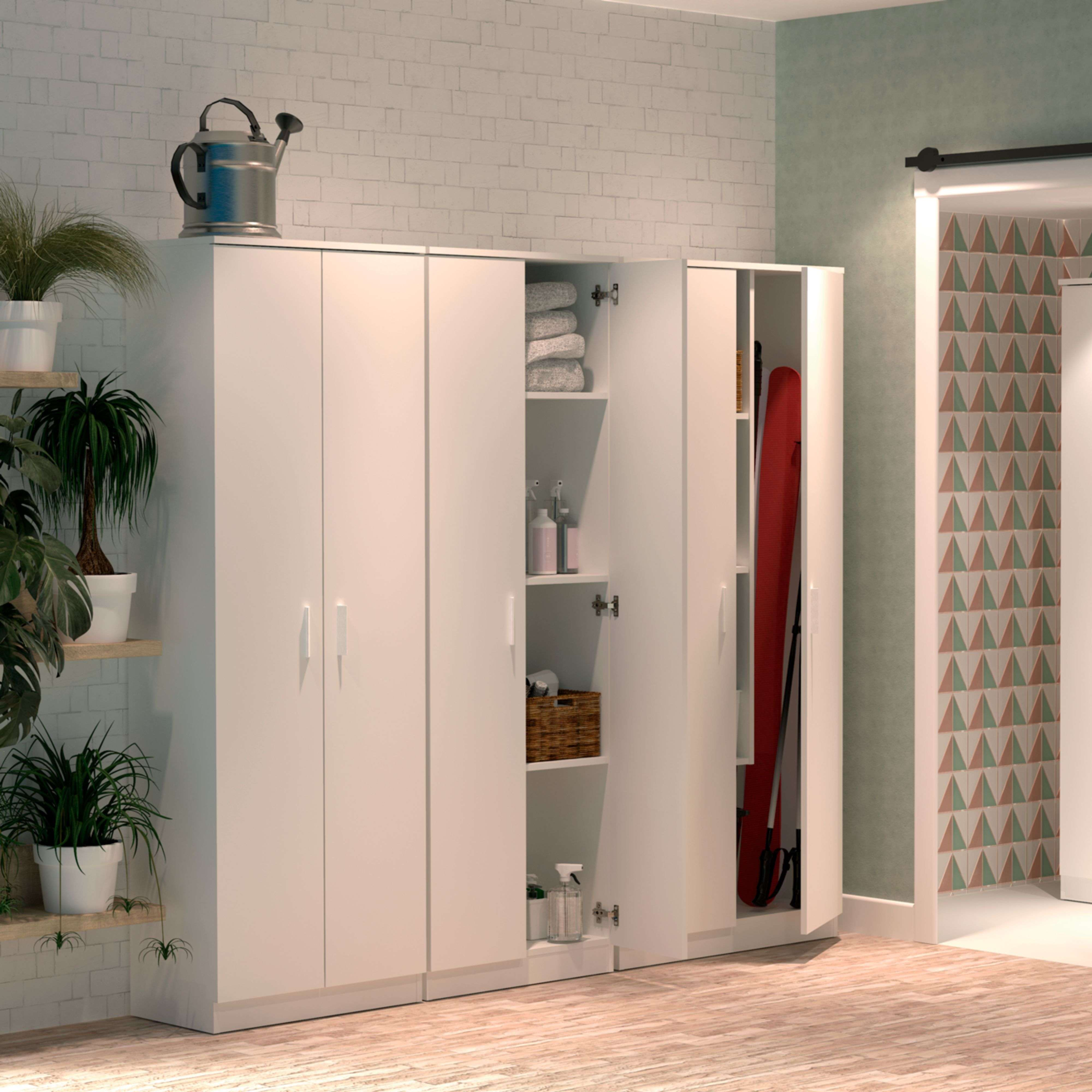 Armarios blancos con puertas abiertas muestran toallas, cesta, productos de limpieza y tabla de surf.