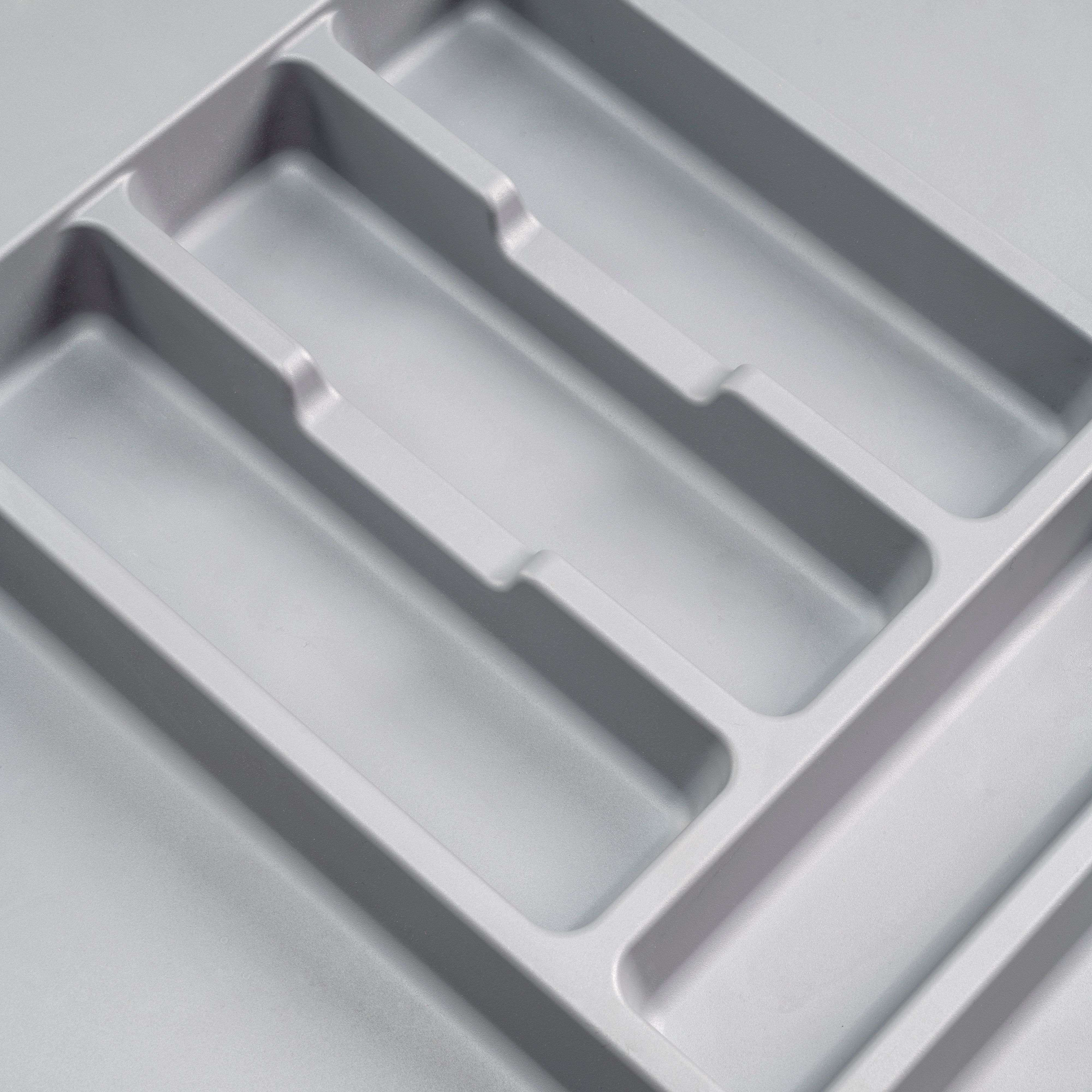 Organizador de cubiertos gris con varios compartimentos, vista cercana.