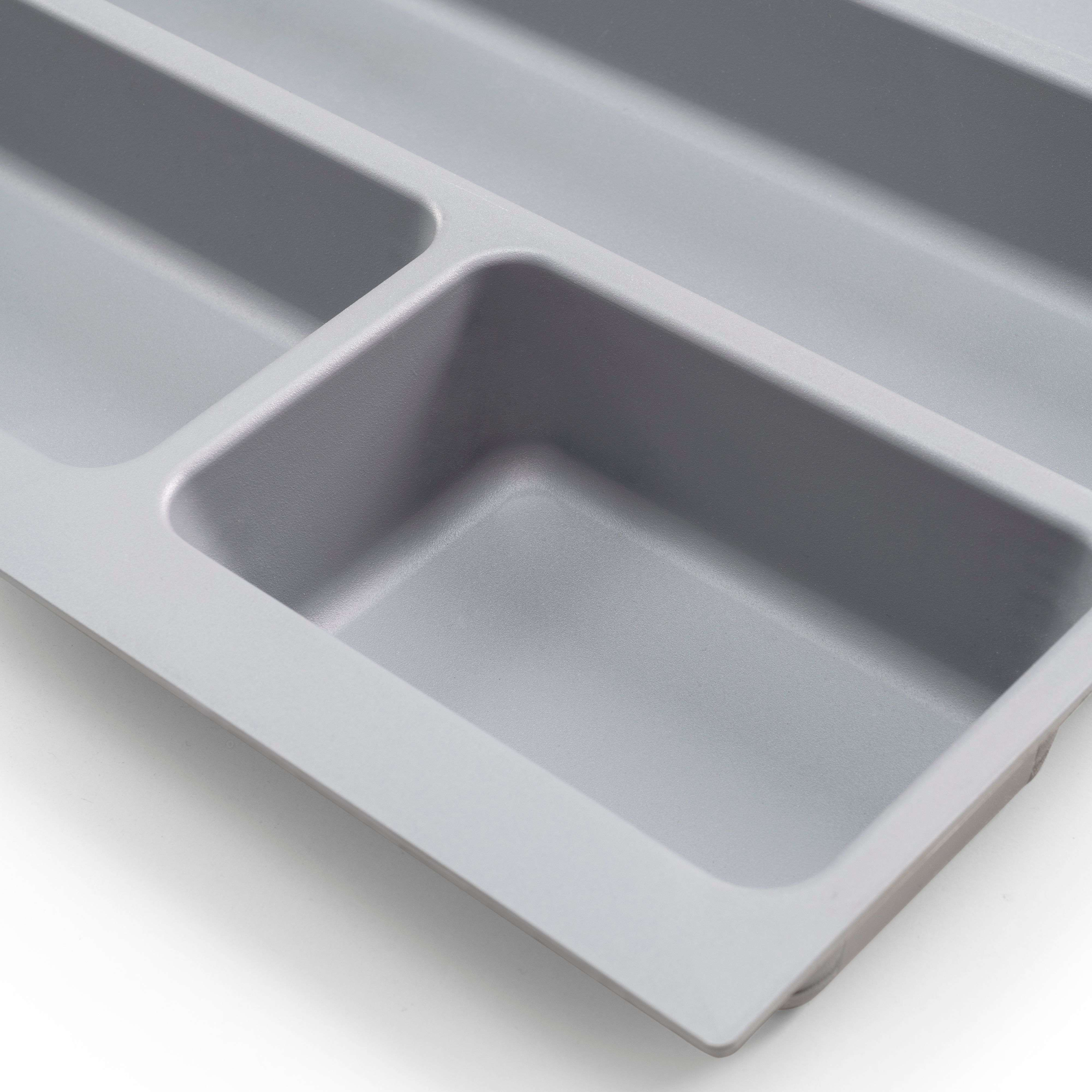 Organizador de utensilios gris con cuatro compartimentos, primer plano.