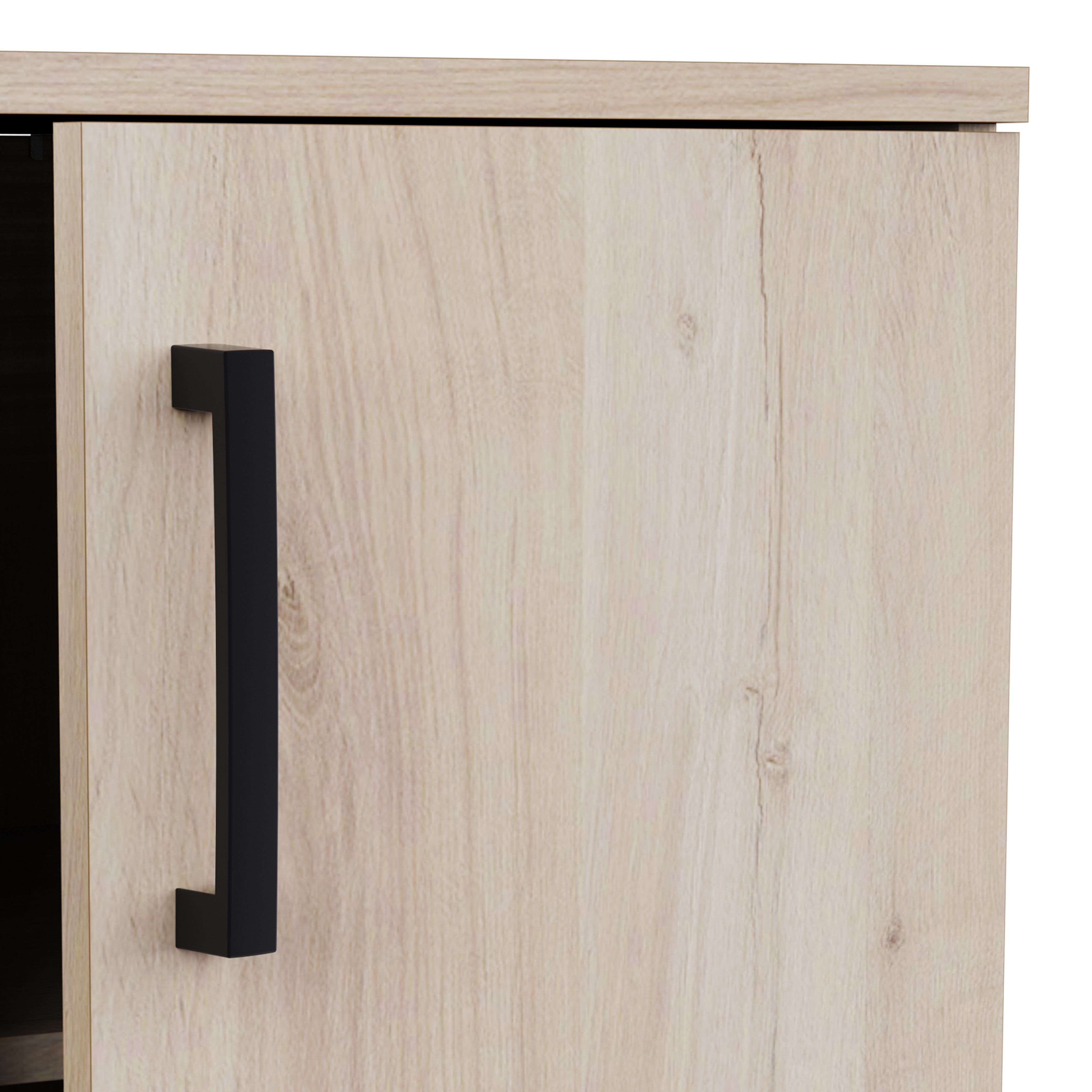Un armario de madera clara con un tirador negro.