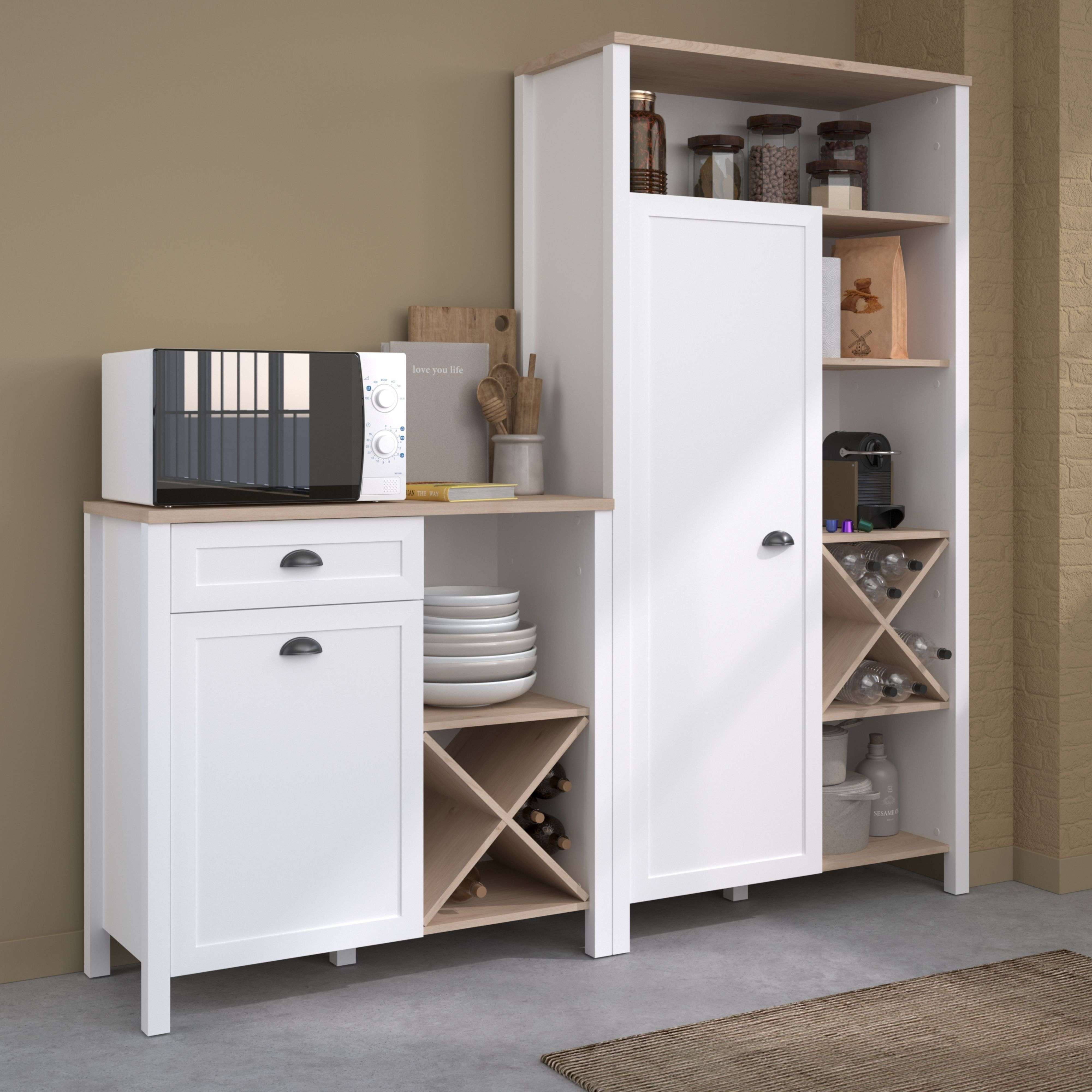 Un mueble de cocina blanco con microondas, platos, botellas y suministros.