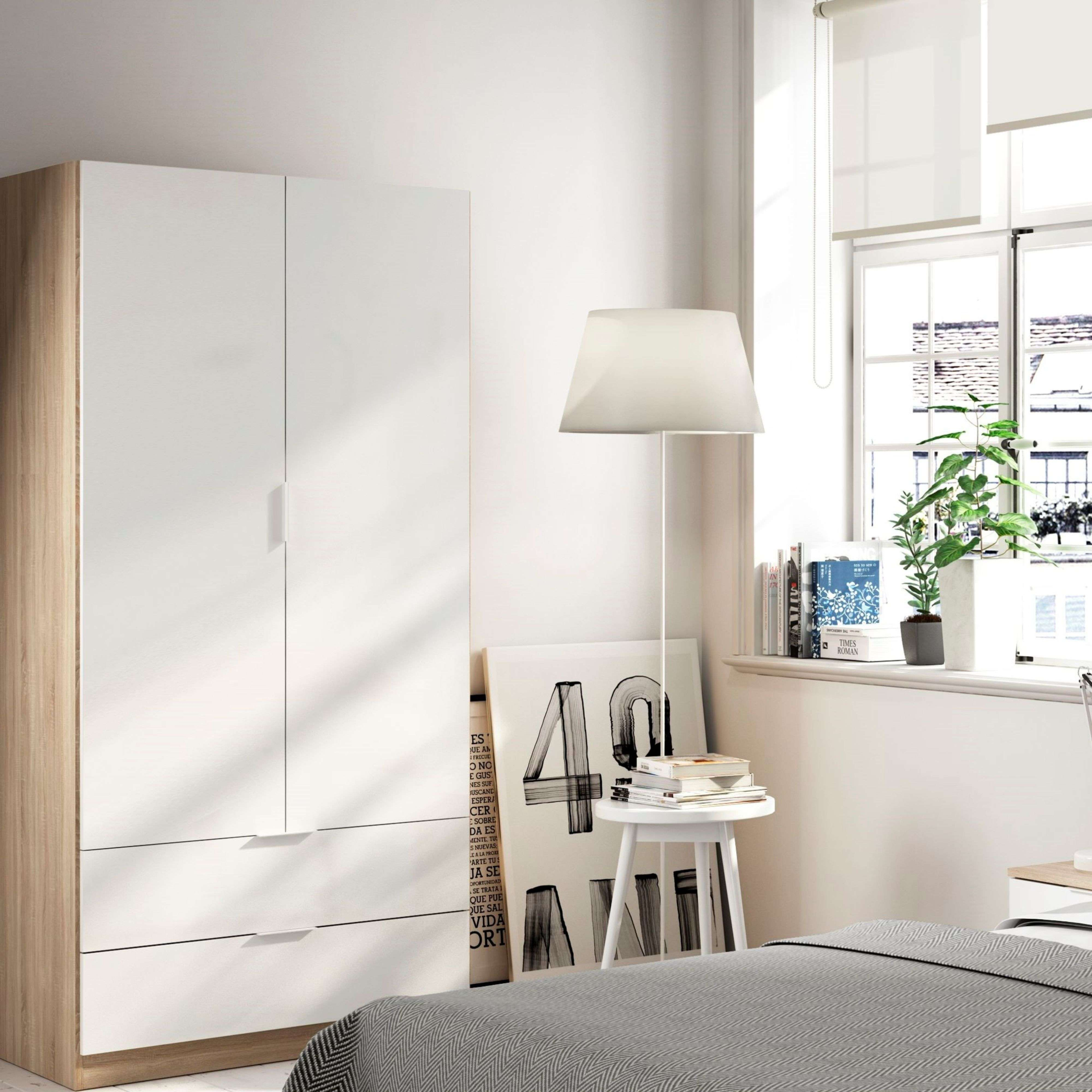 Un dormitorio con armario blanco, cama y ventana.