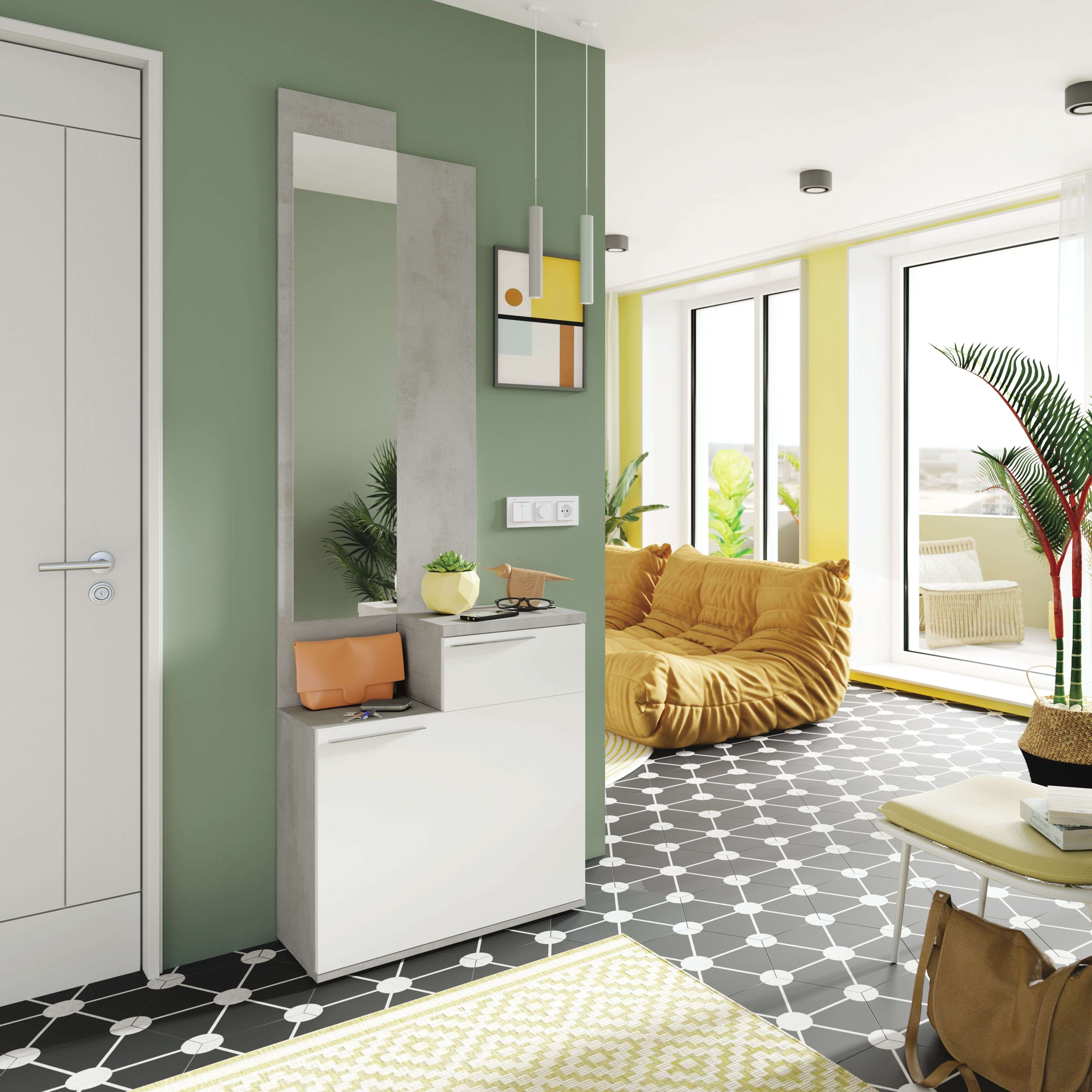 Pasillo moderno con espejo de pared, sofá amarillo y suelo estampado.