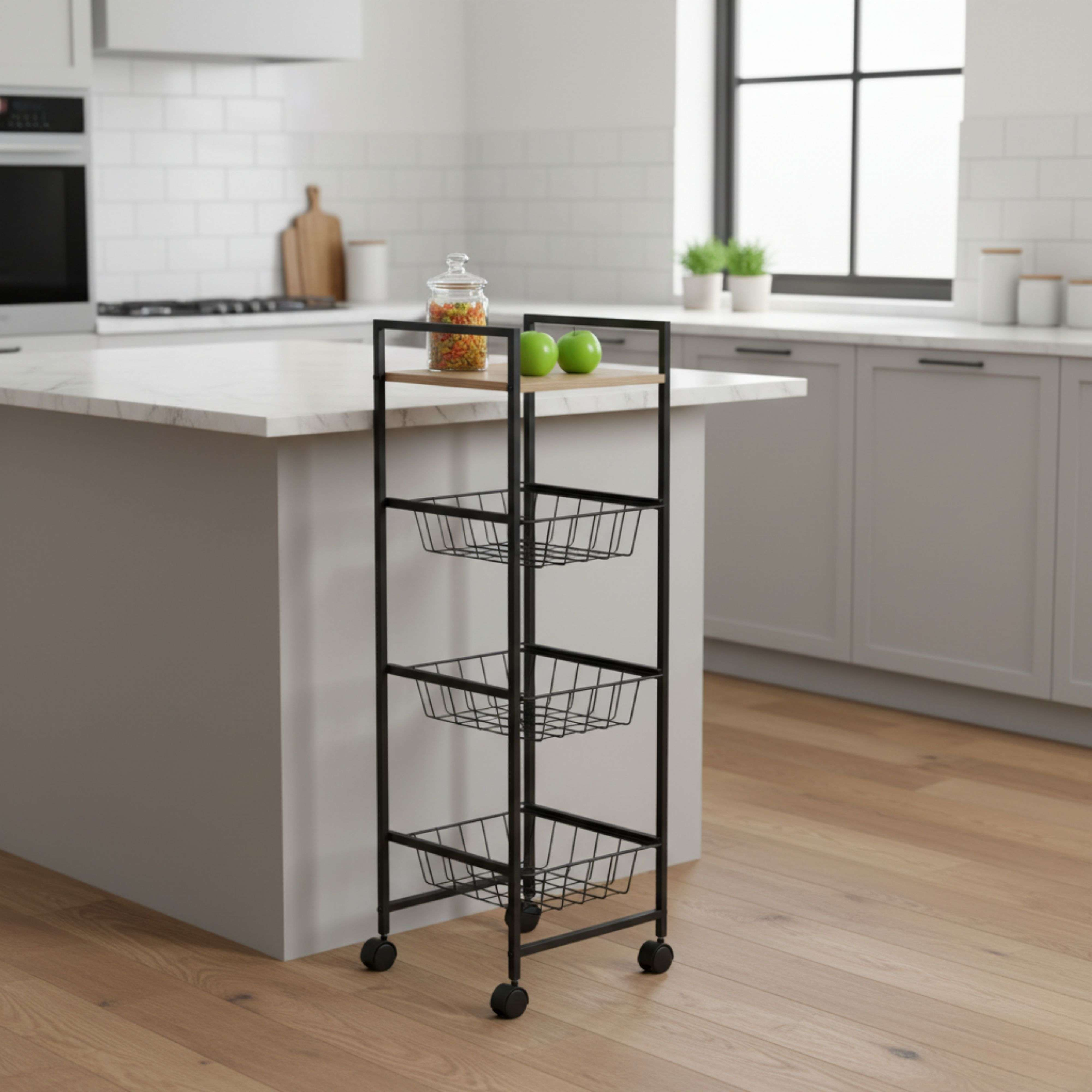Un carrito de cocina negro de metal con tres cestas sobre suelo de madera.