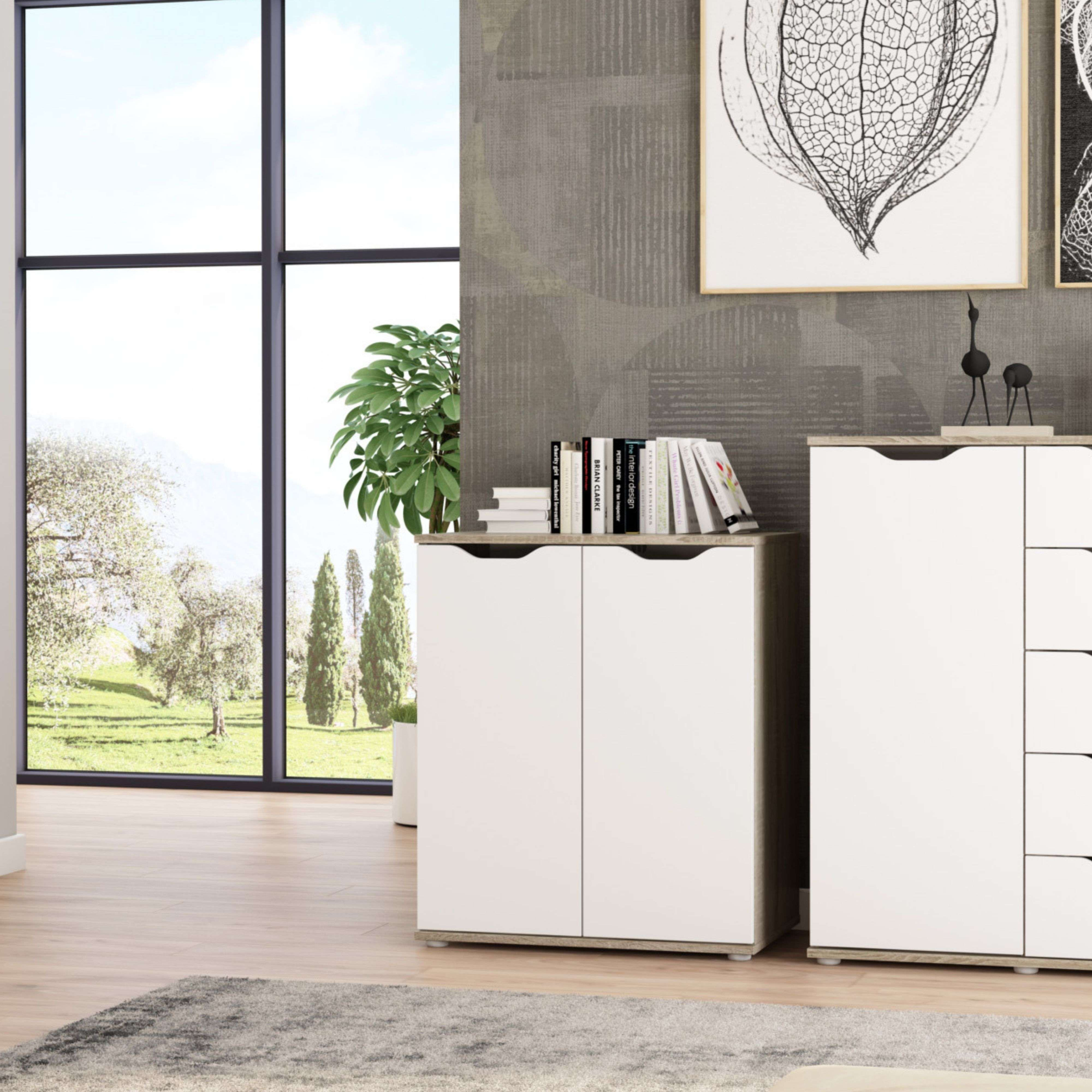 Un gabinete blanco con libros y decoración junto a una gran ventana con vista a la naturaleza.