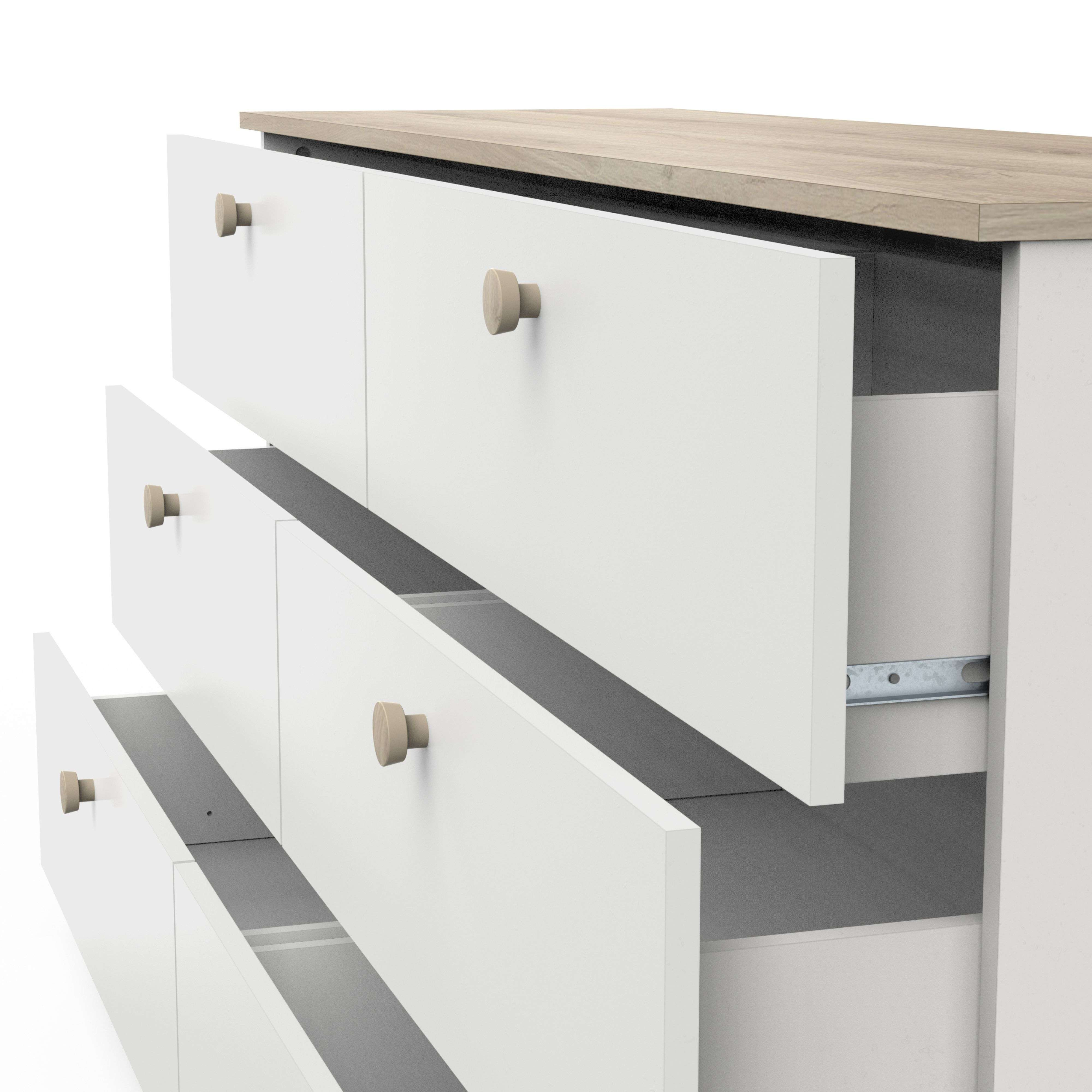 Cómoda blanca con detalles de madera, cajones parcialmente abiertos.