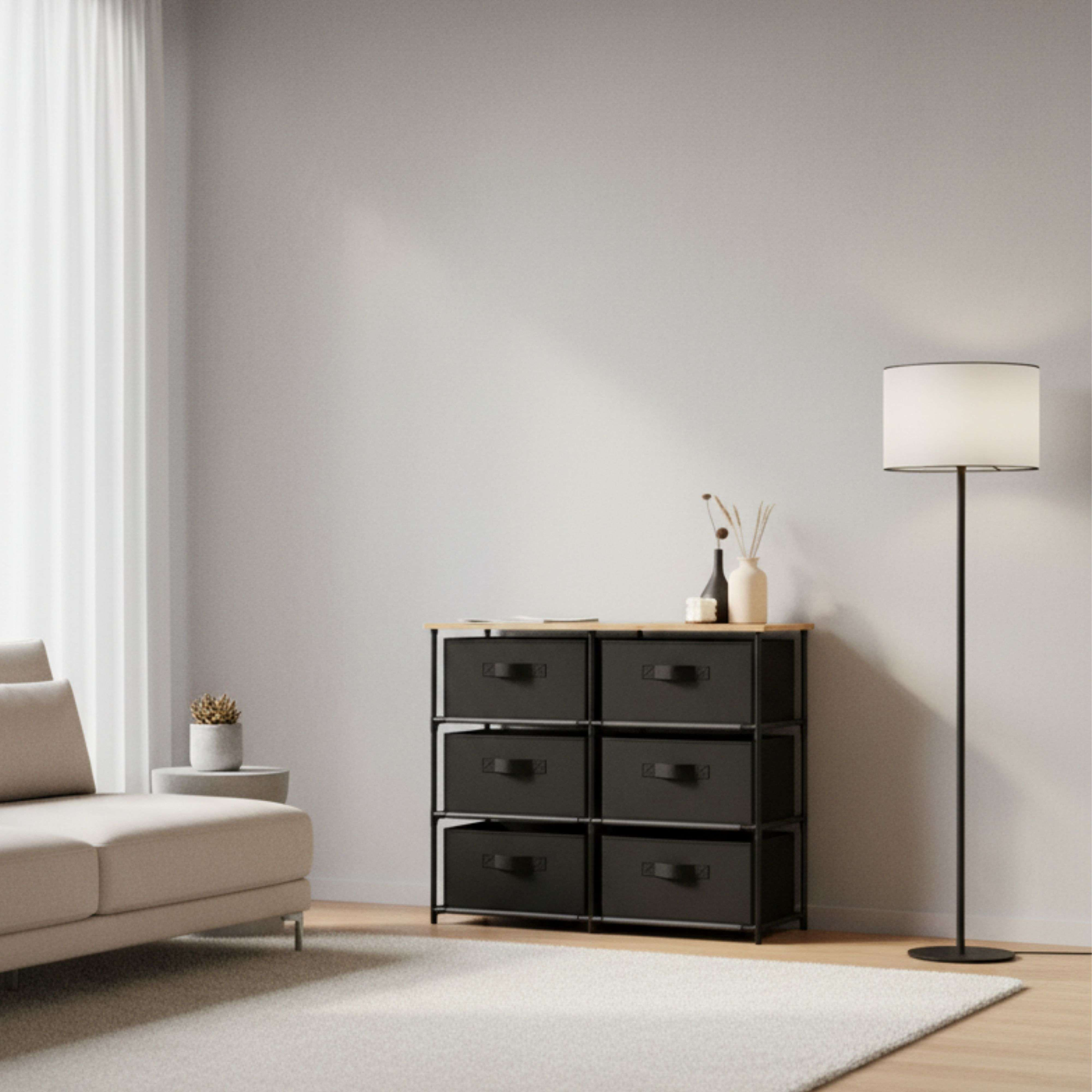 Una sala de estar con sofá, cómoda, lámpara y cortina.