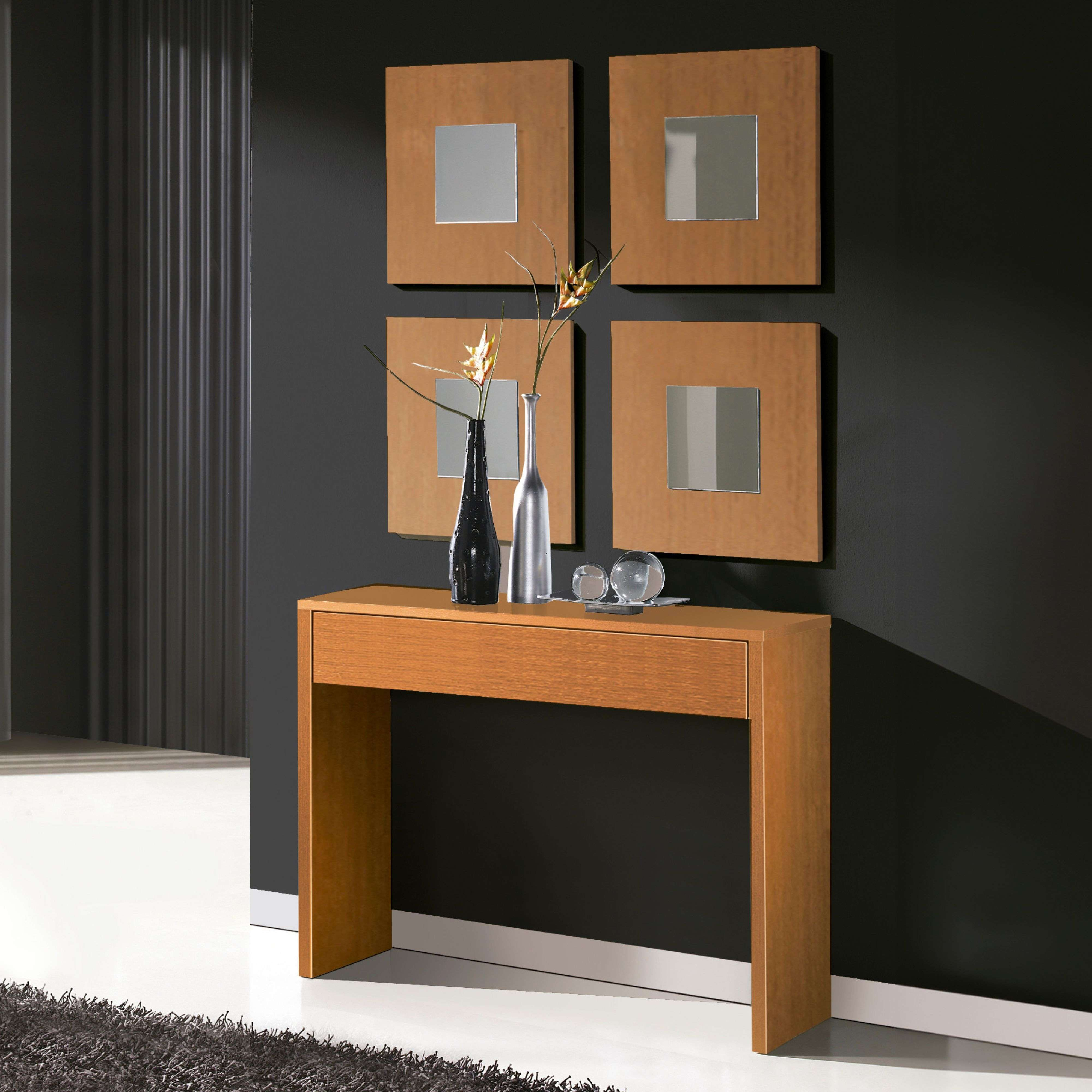 Una mesa estrecha de madera con dos jarrones y decoración frente a una pared oscura con cuatro espejos cuadrados.
