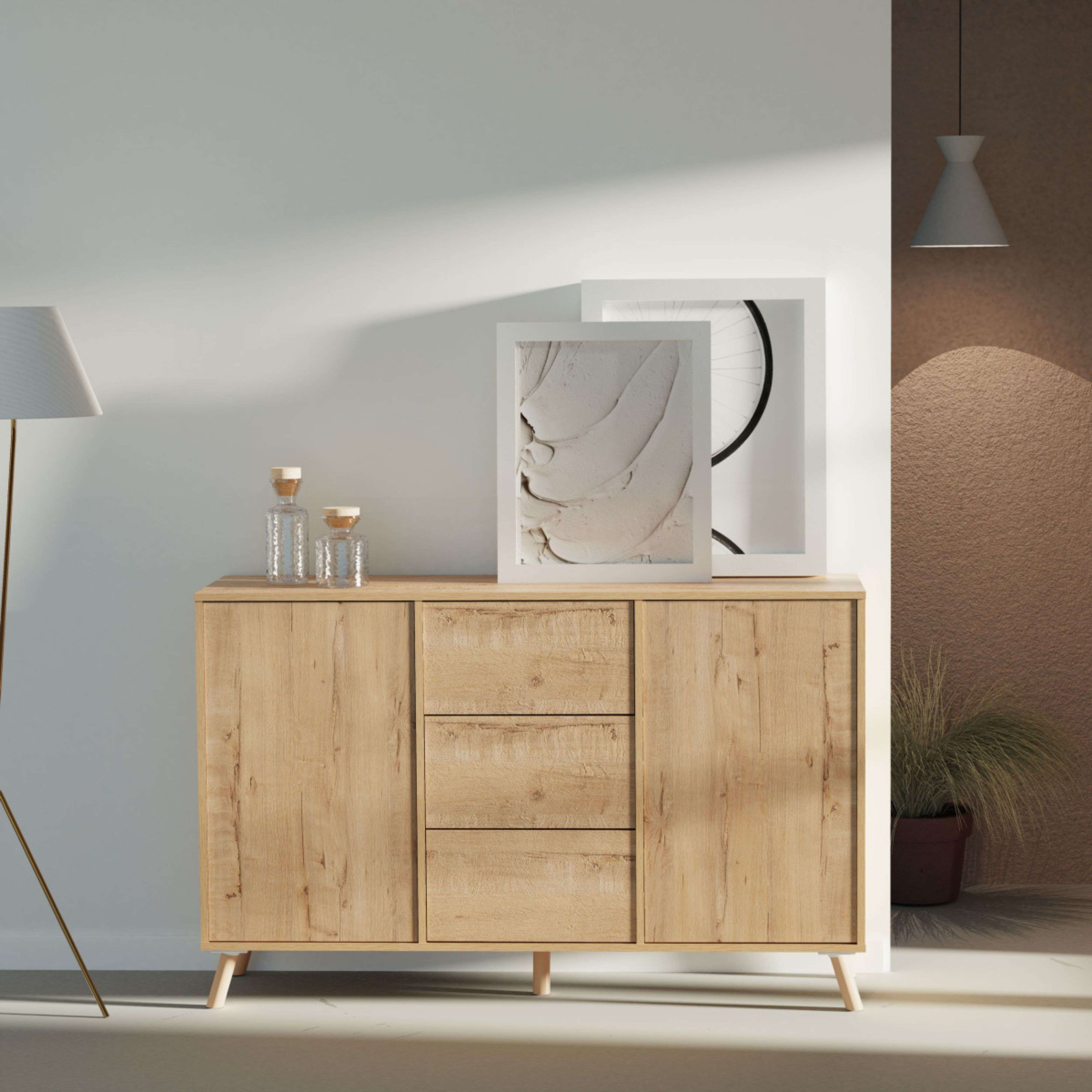 Un aparador de madera con tres cajones y dos puertas, decorado con jarrones y cuadros.