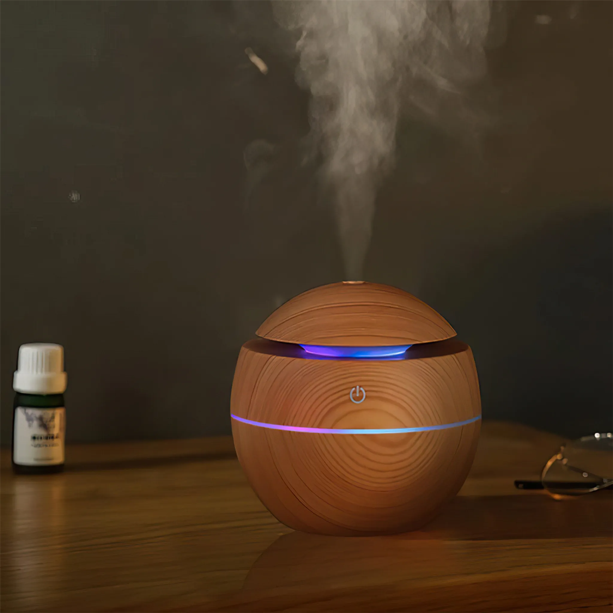 Ein runder Holz-Diffusor gibt Dampf ab, beleuchtet mit blauen und violetten Lichtern.