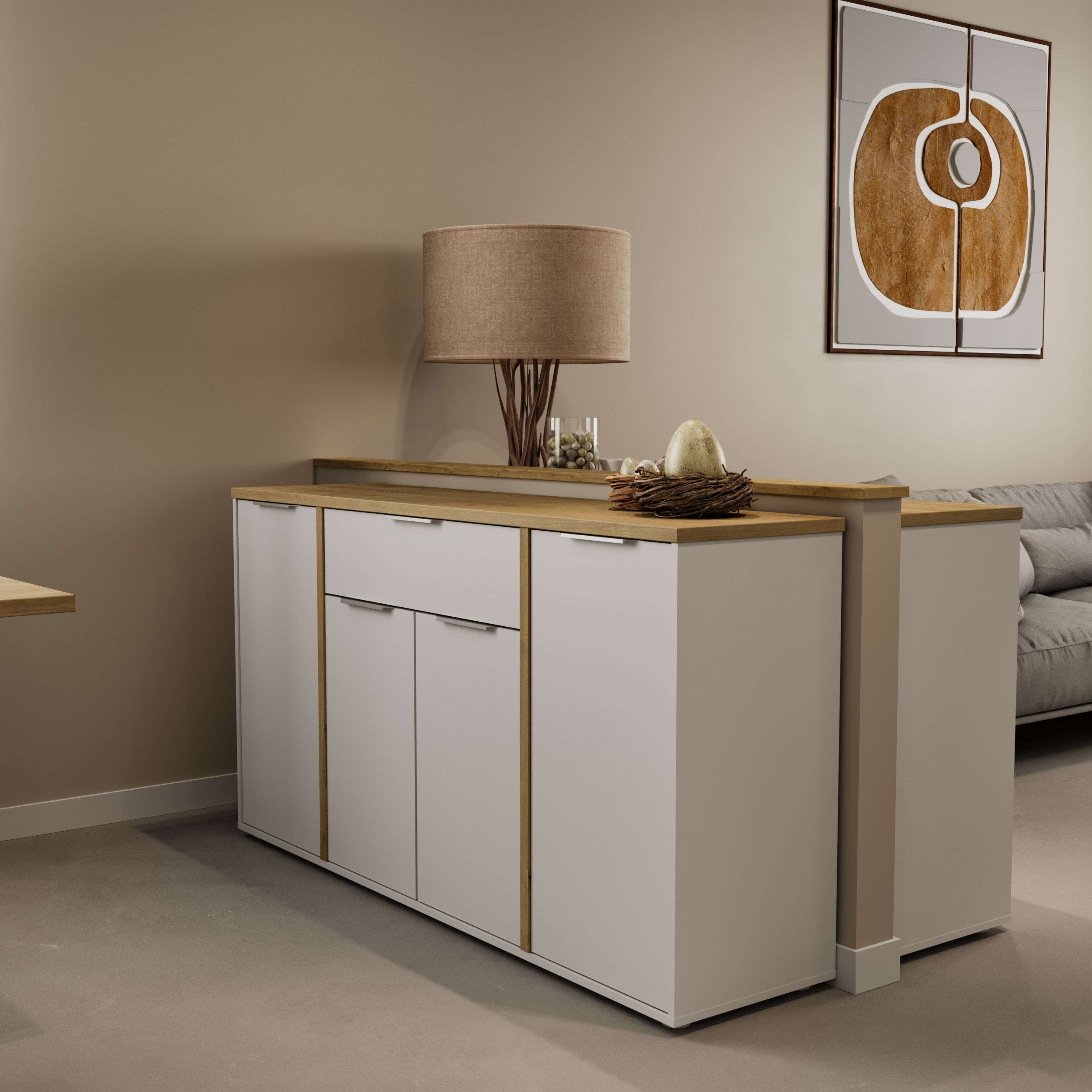 Un mueble blanco con detalles de madera y una lámpara, junto a un nido con huevos.