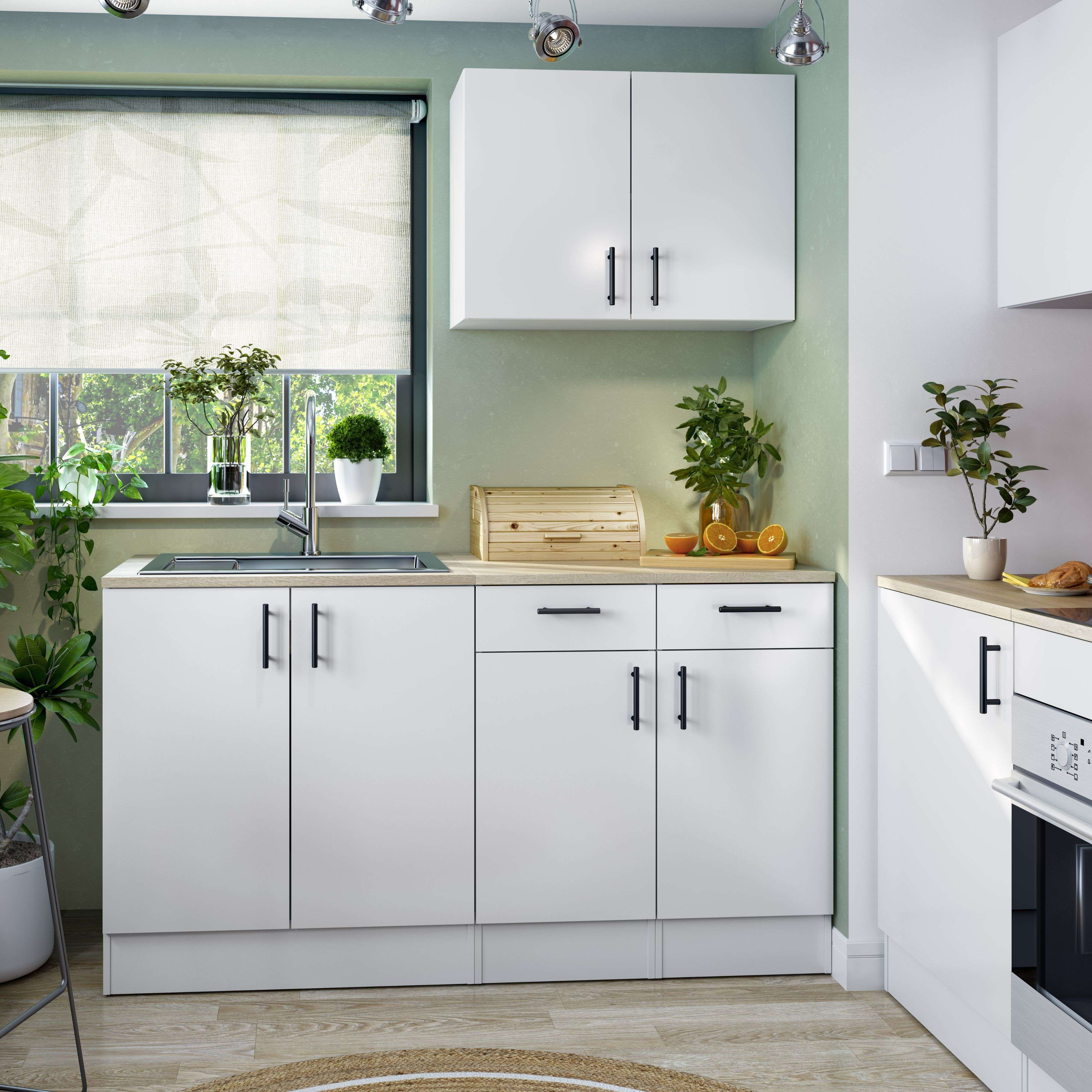 Cocina blanca moderna con fregadero, ventana, plantas y panera de madera.