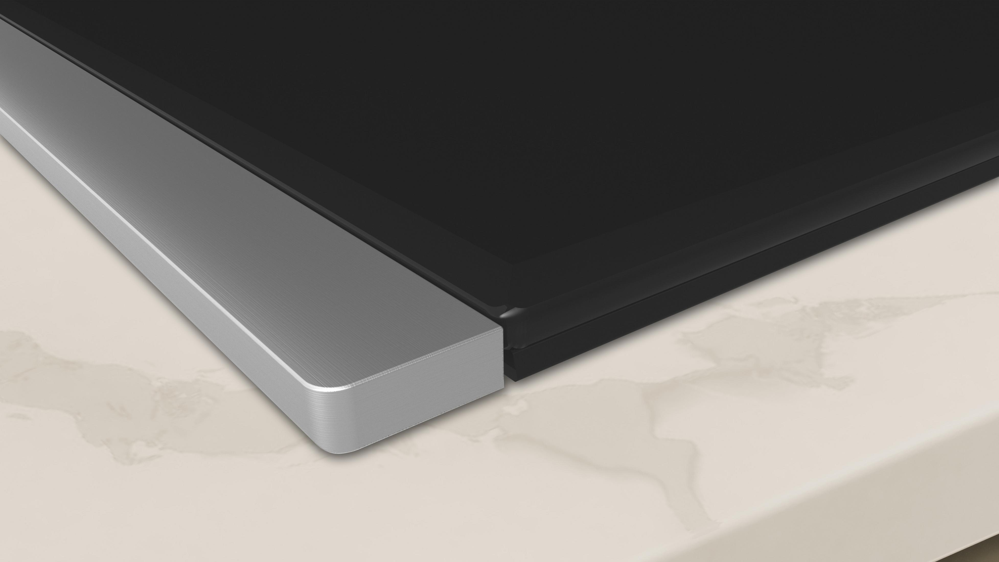 Fragment płyty grzewczej ze srebrną krawędzią i czarną powierzchnią.