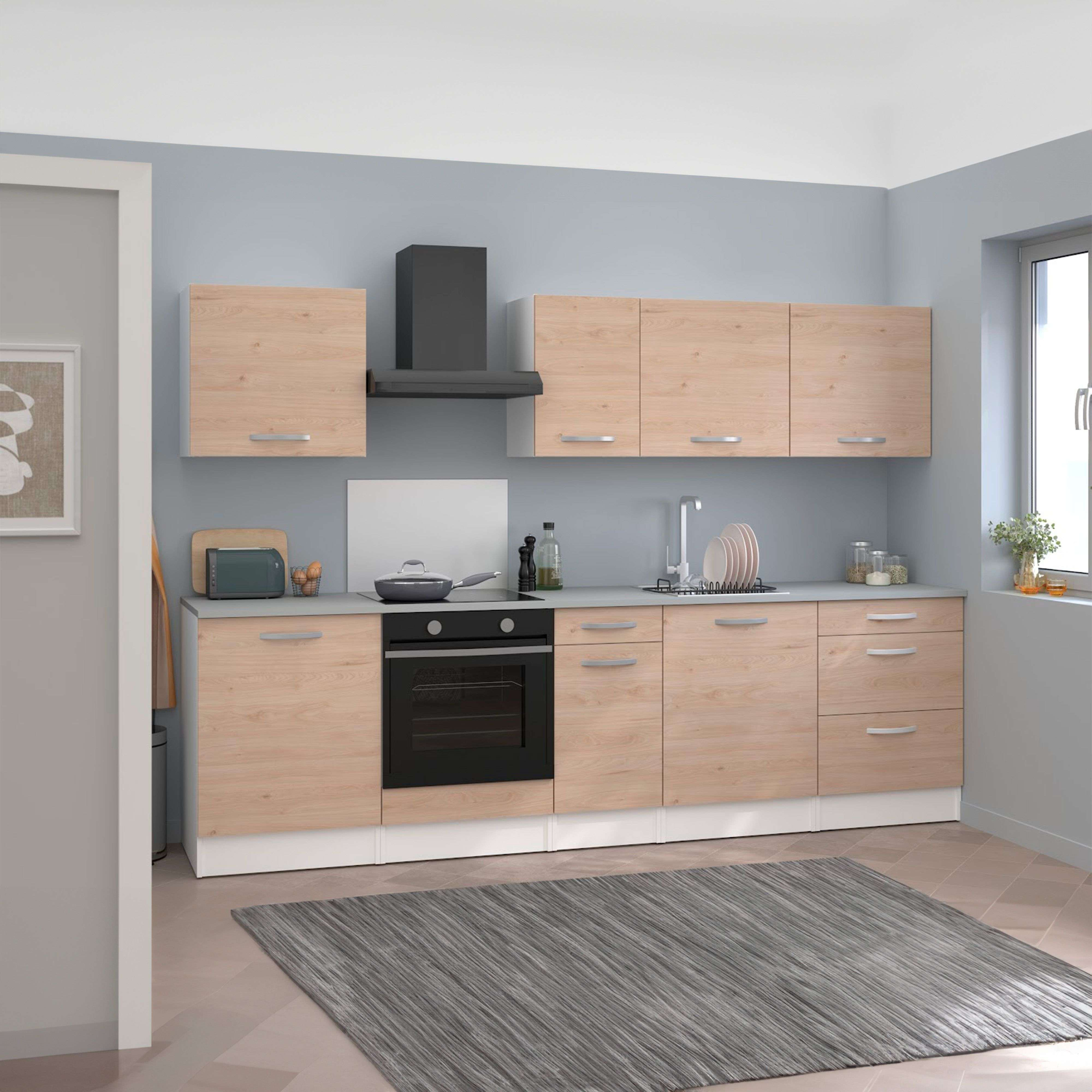 Cocina moderna con gabinetes de madera clara, campana negra y alfombra gris.