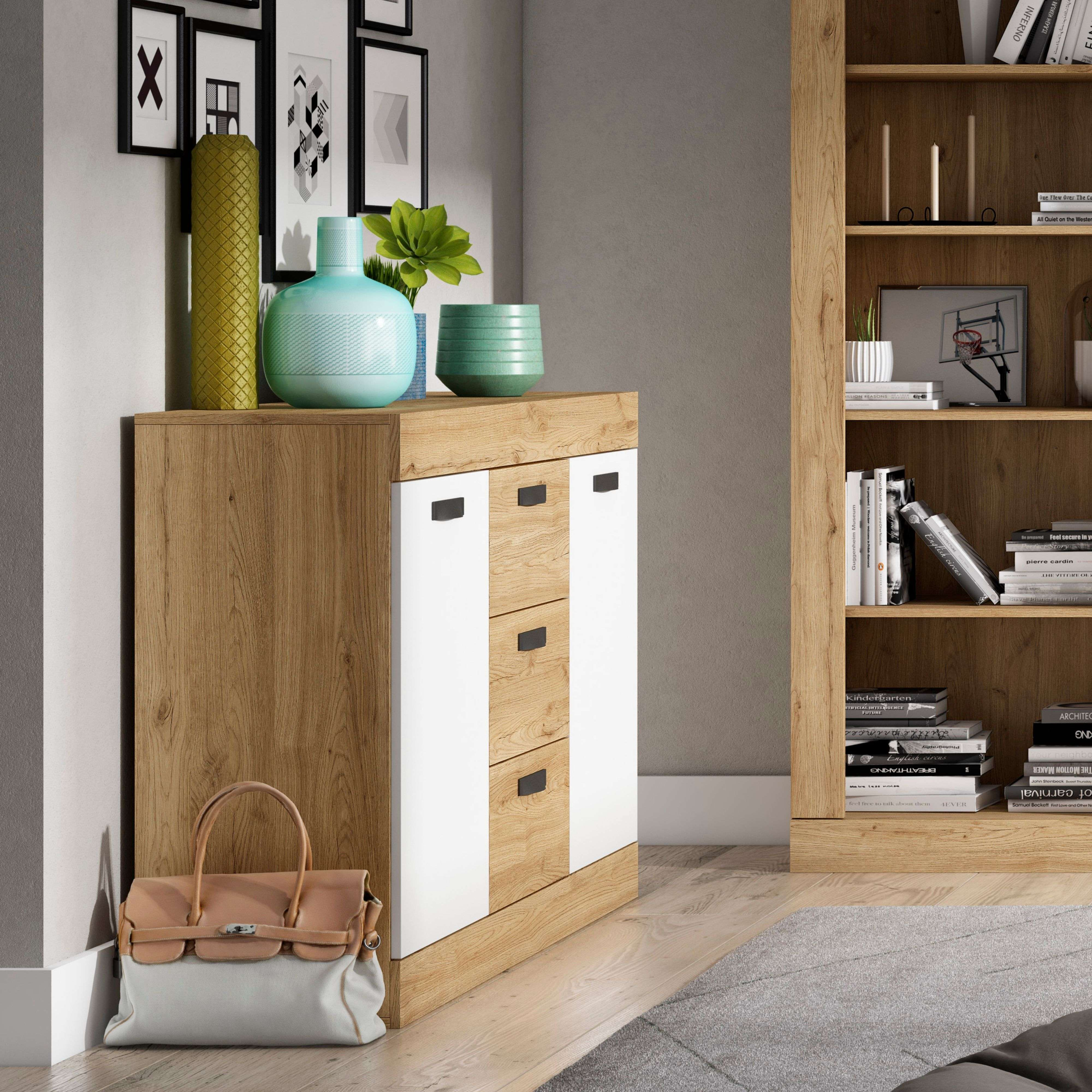 Cómoda de madera con puertas y cajones blancos, junto a una estantería.