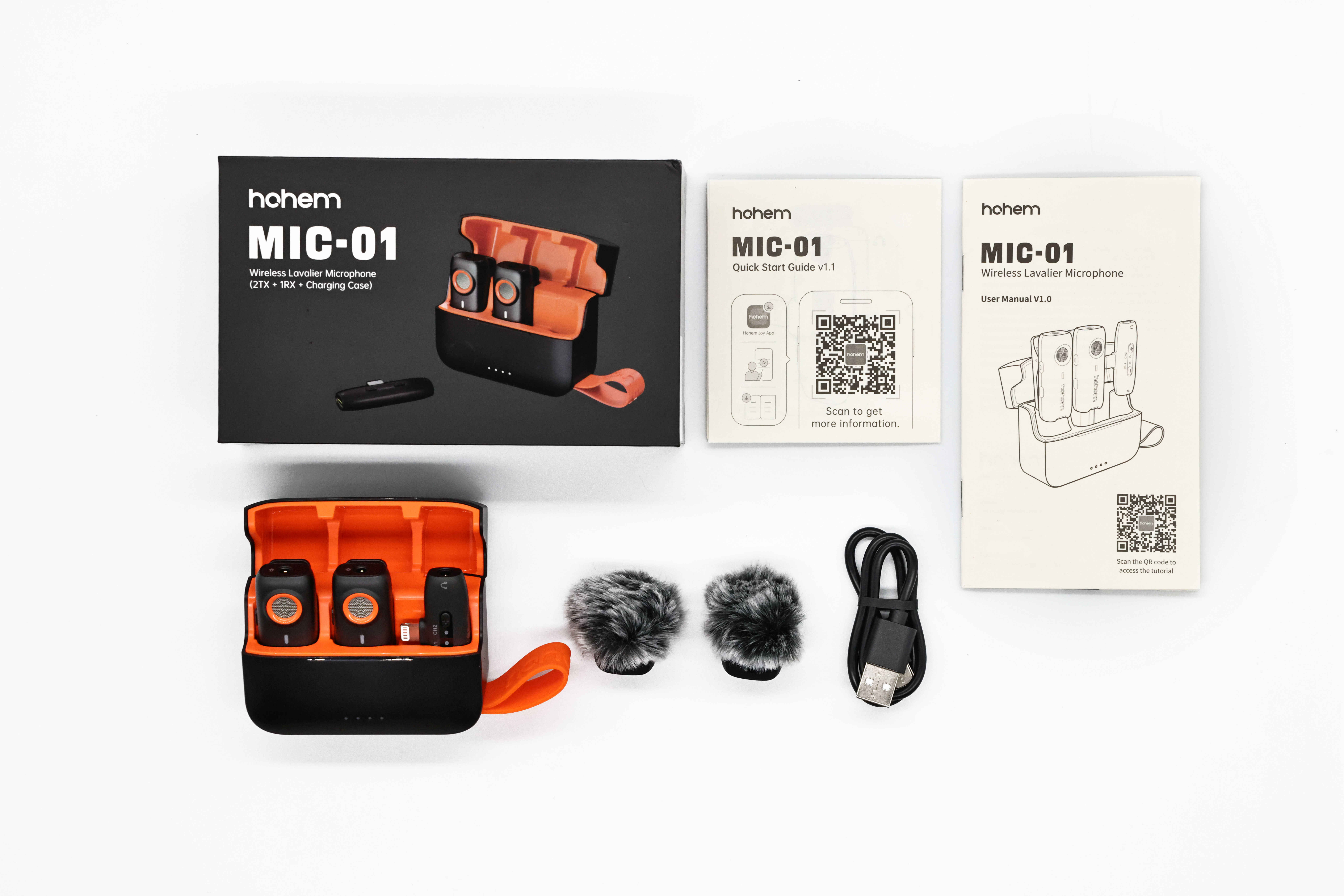 Mikrofony Hohem MIC-01, etui ładujące, osłony przeciwwiatrowe i kabel na białym tle.