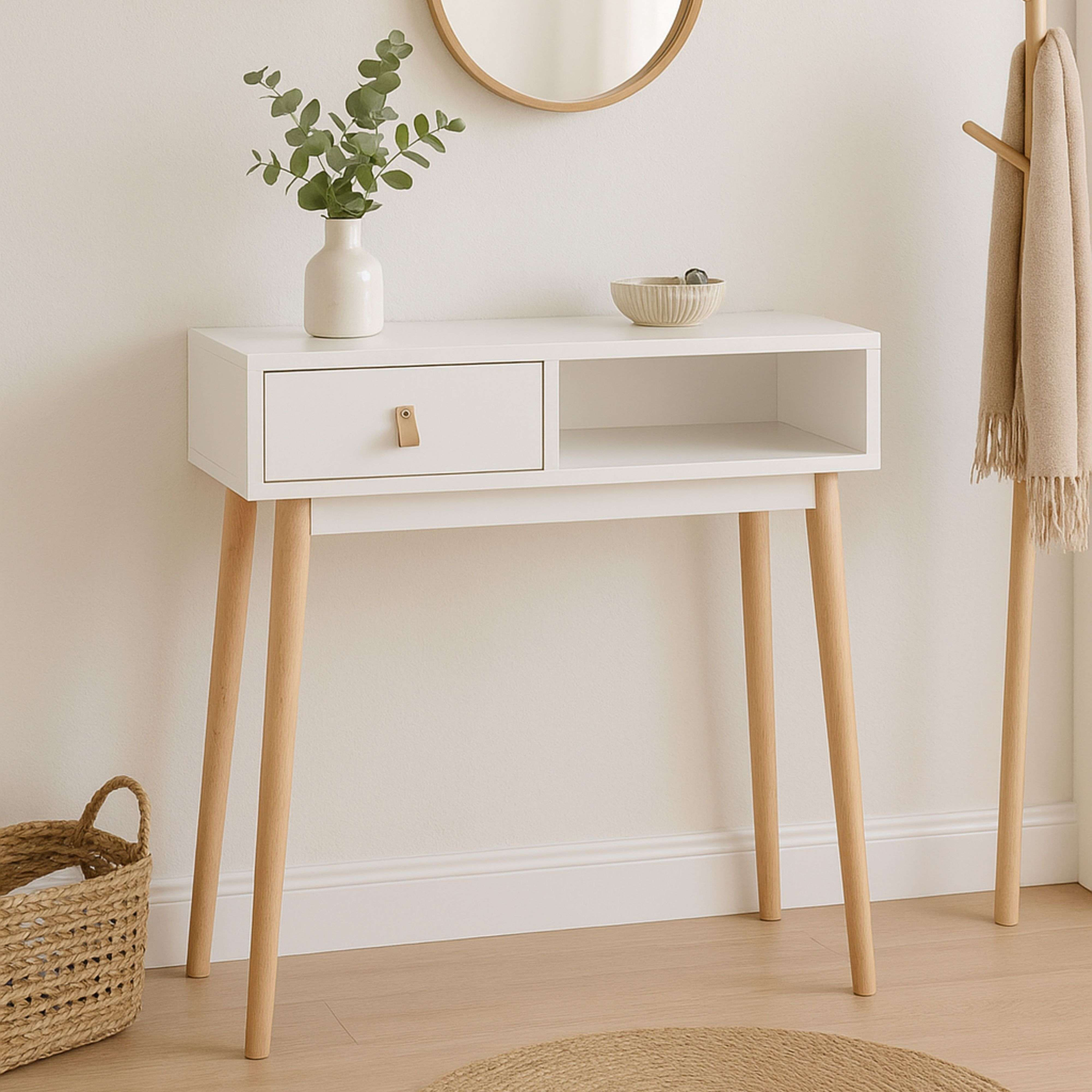 Una mesa consola blanca con patas de madera, un cajón y un estante abierto.