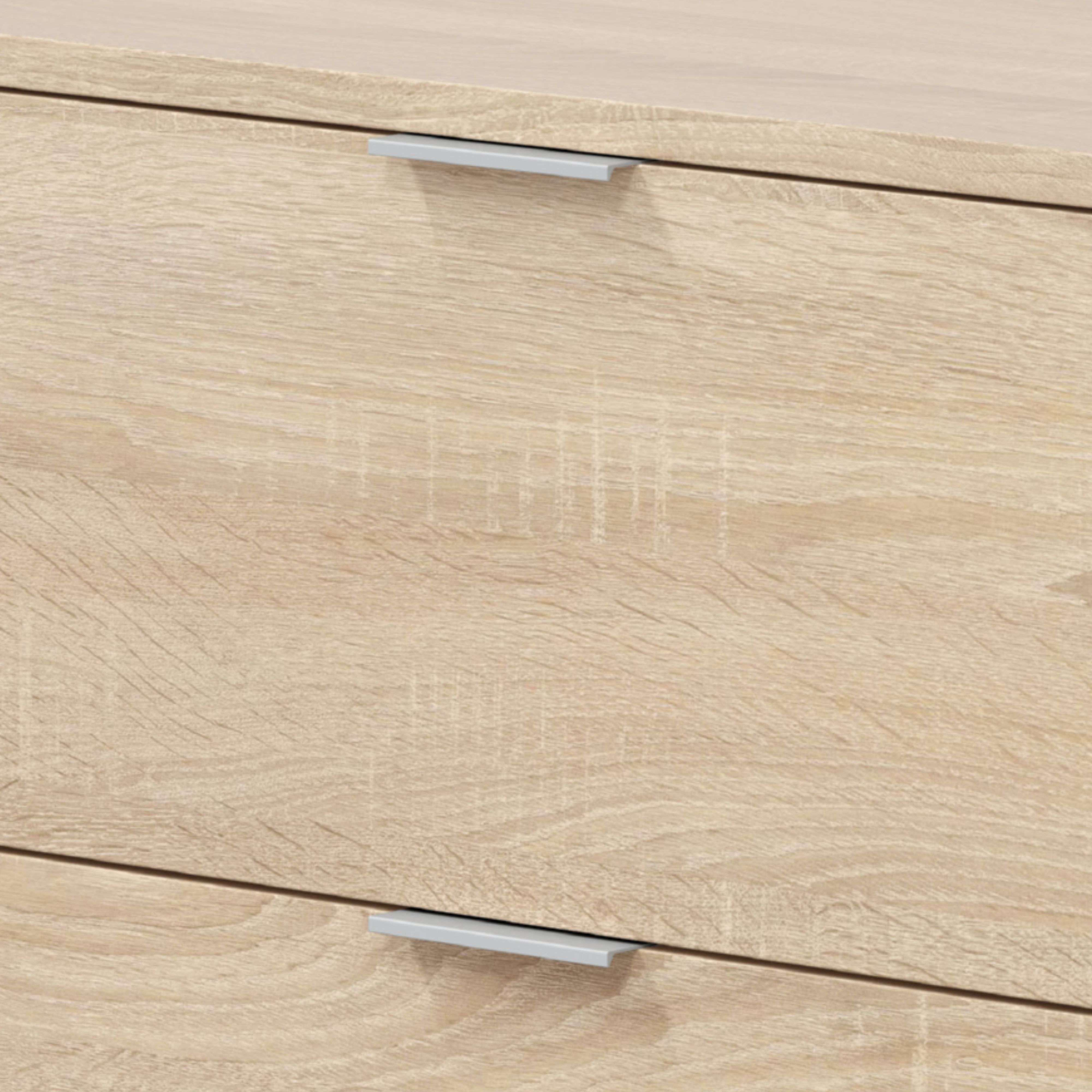 Primer plano de veta de madera con dos tiradores plateados en cajones.