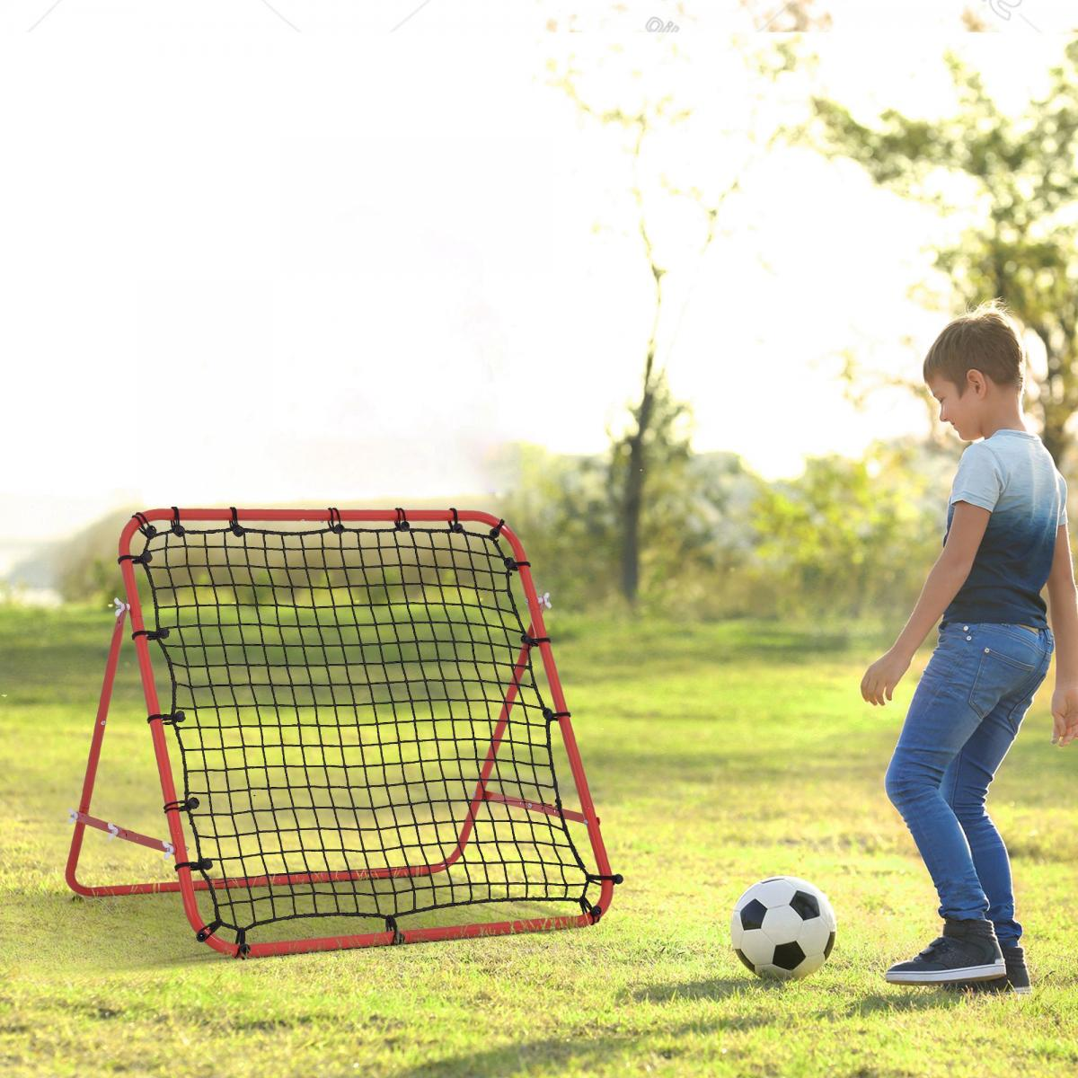 Ein Junge spielt mit einem Fußball vor einem roten Fußball-Rückprallnetz im Freien.