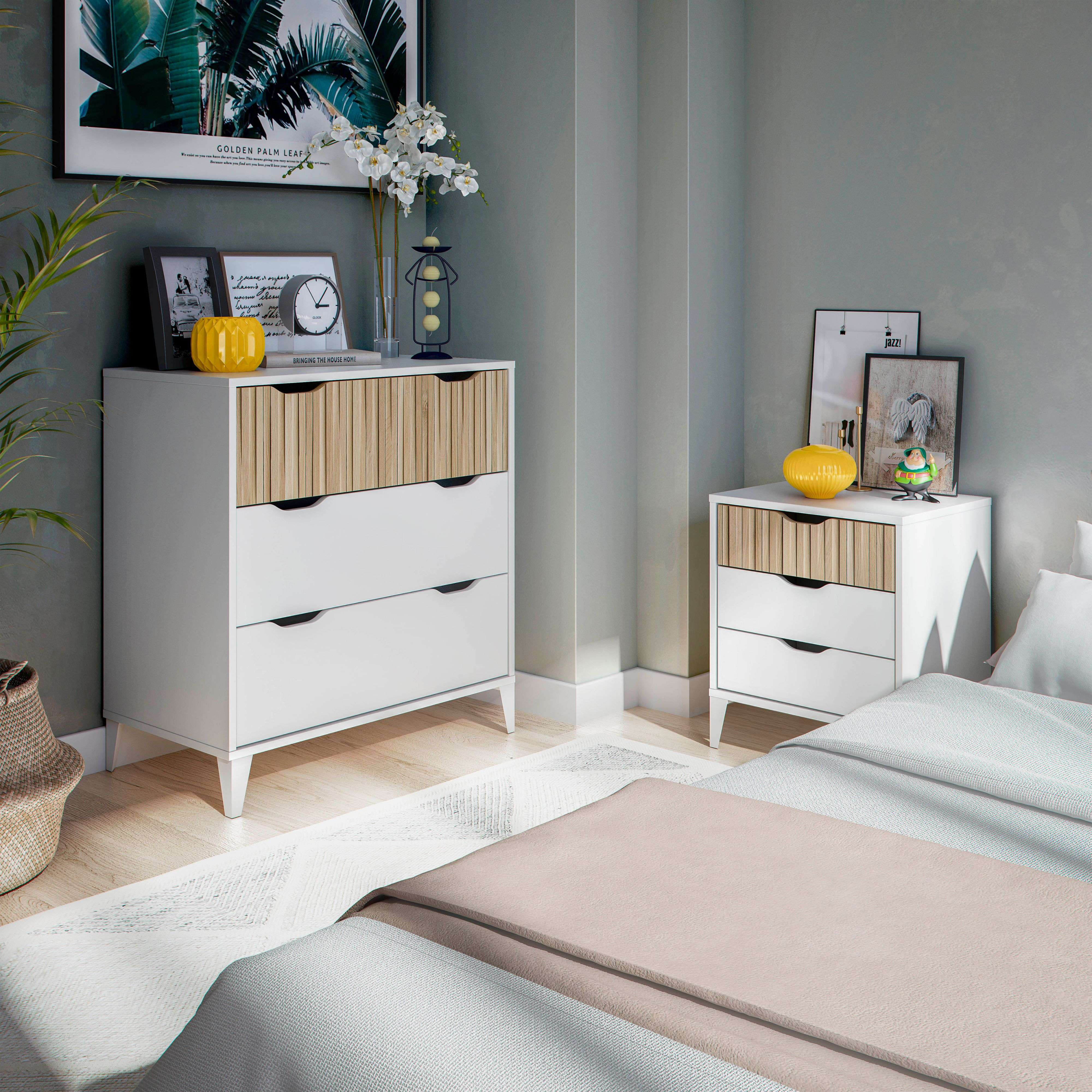 Un dormitorio con muebles blancos, arte y plantas.