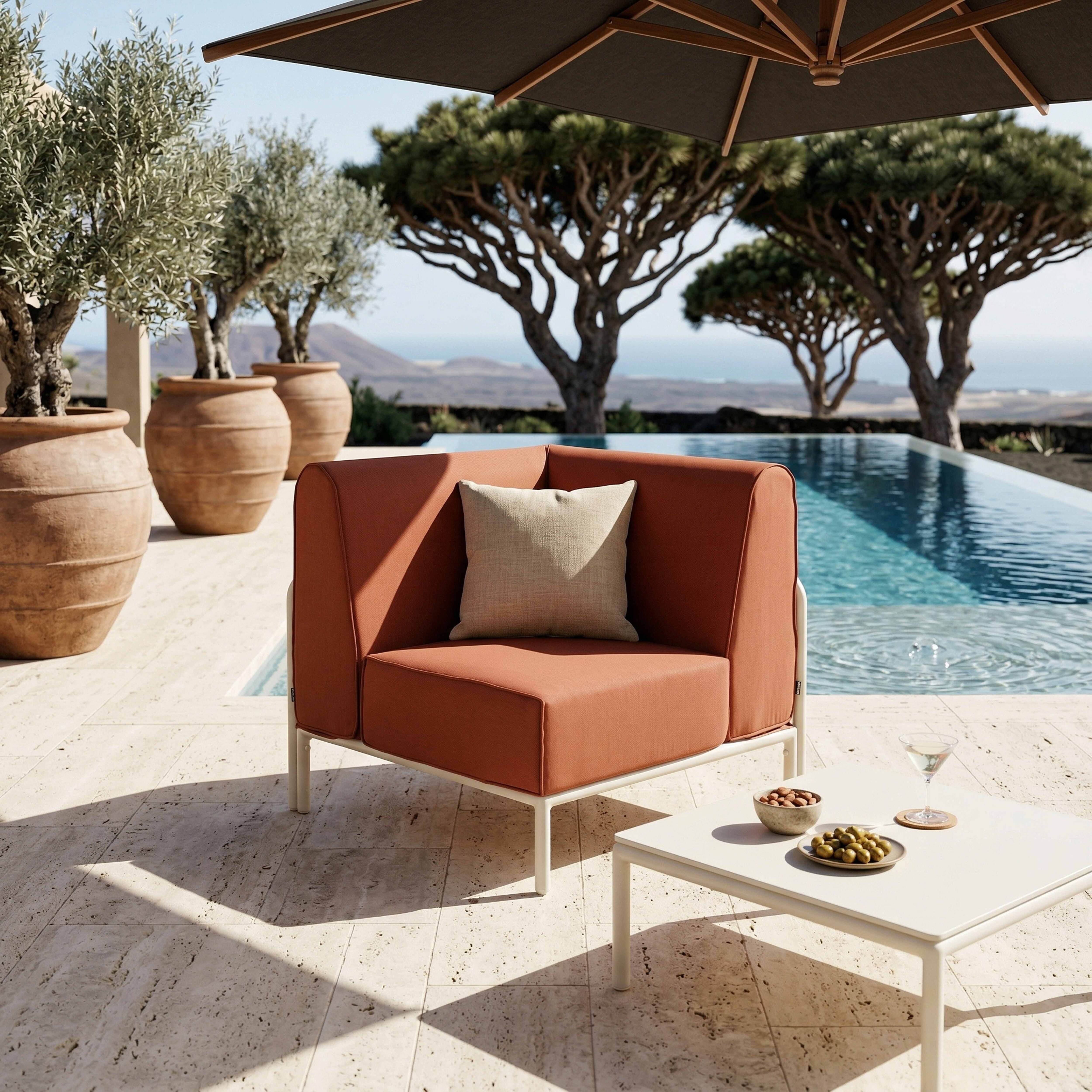 Terrasse mit Swimmingpool, braunem Sessel, Olivenbäumen und einem Sonnenschirm.