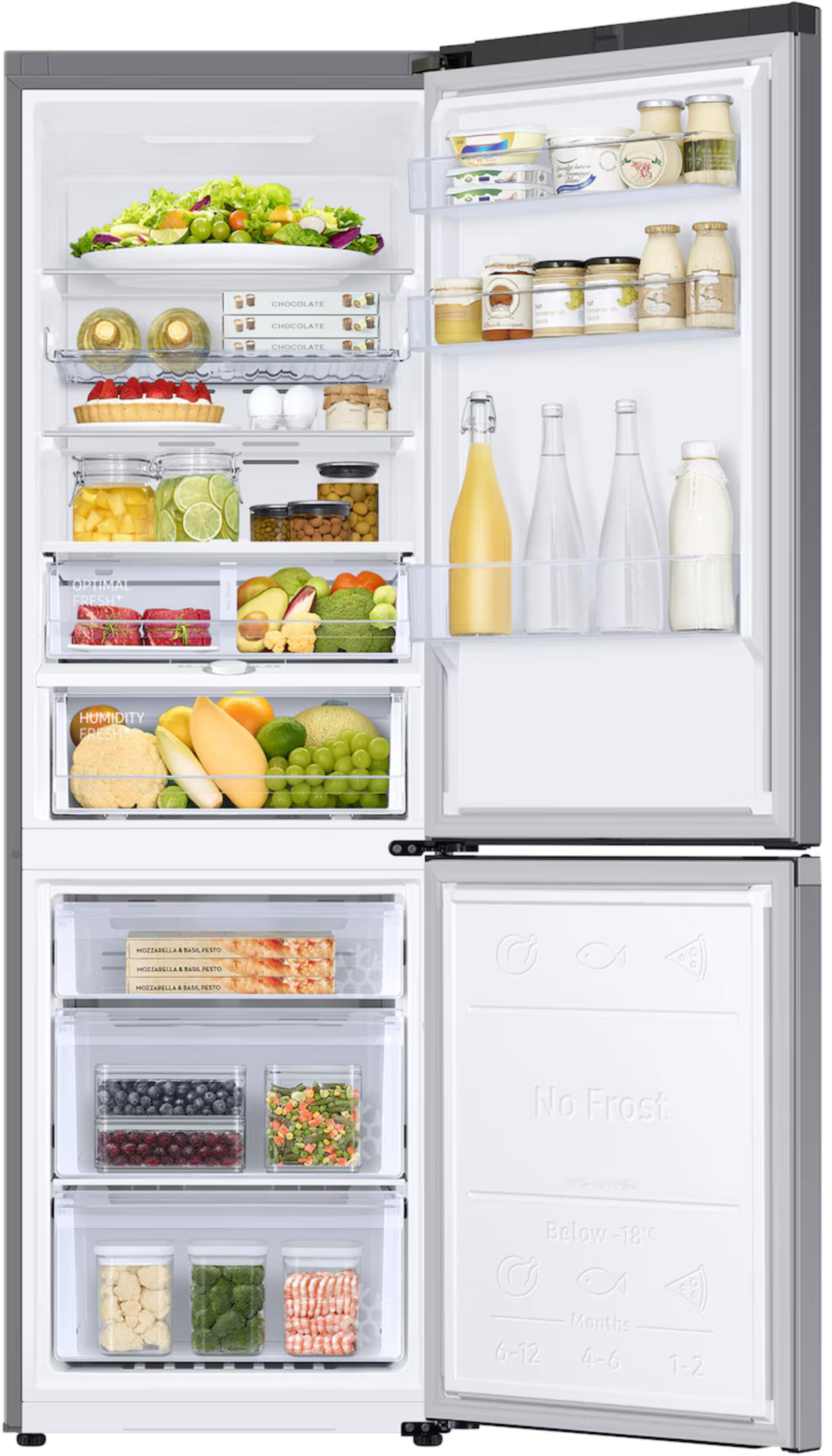 Un frigorifero aperto pieno di cibo: insalata, frutta, verdura, cioccolato e bevande.