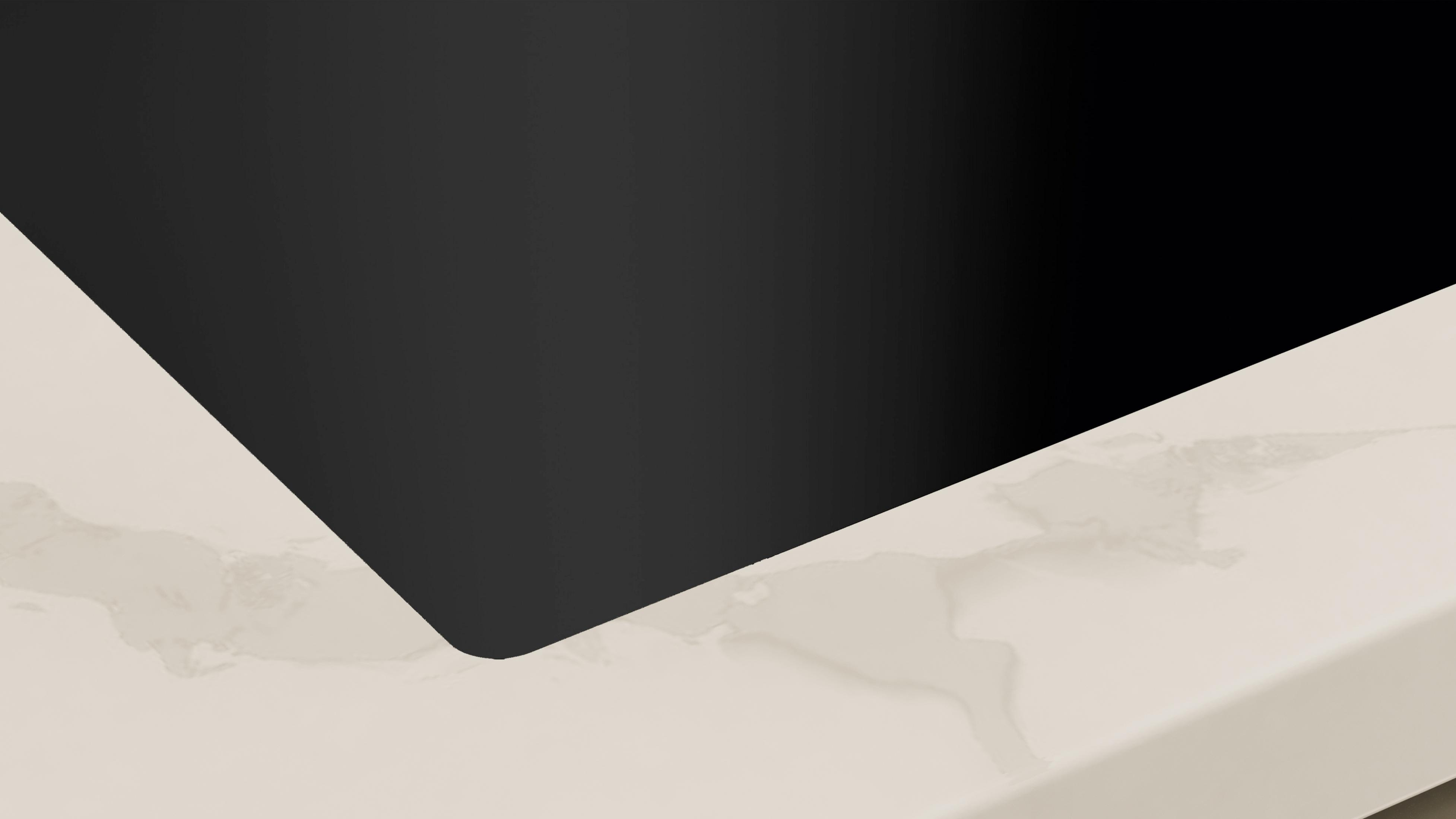 Zbliżenie czarnej powierzchni graniczącej z kremowym blatem marmurowym.